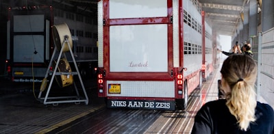 Woman looking at livestock trucks parked in a facility.