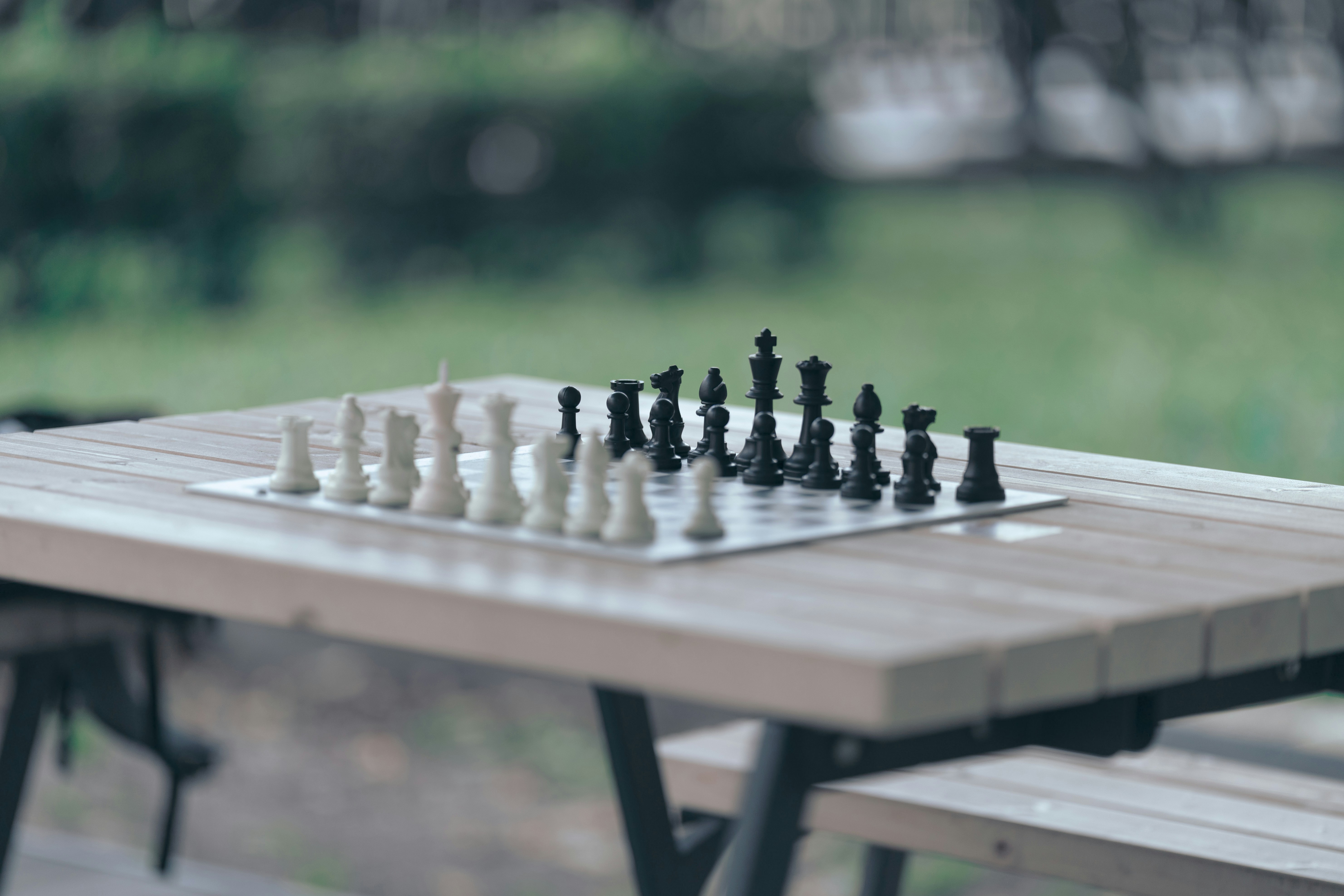 Chess pieces arranged on a board on a table.