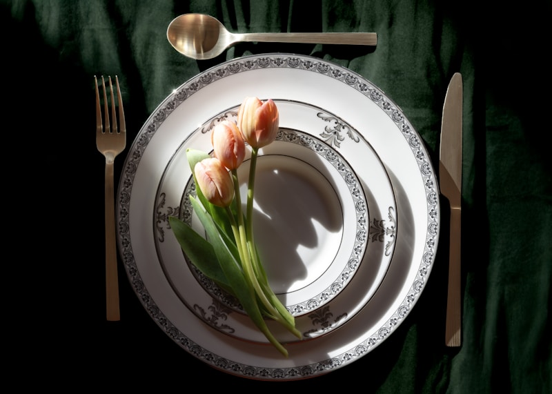 Elegant place setting with tulips on a dark green tablecloth