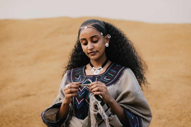 Ethiopian Silver Jewellery Through Time Woman in traditional clothing holds yarn in desert