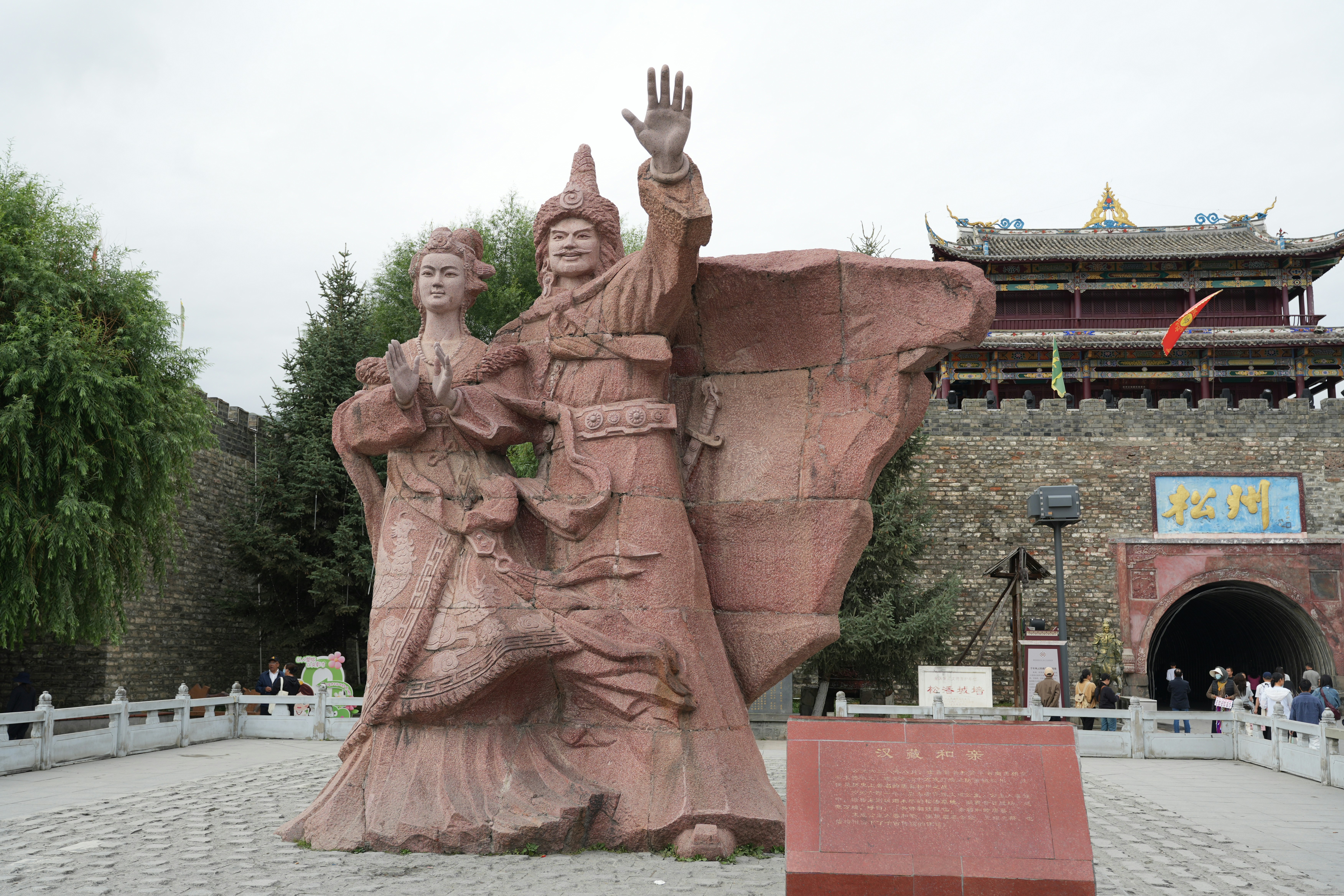 Statue of two figures in front of historical gate