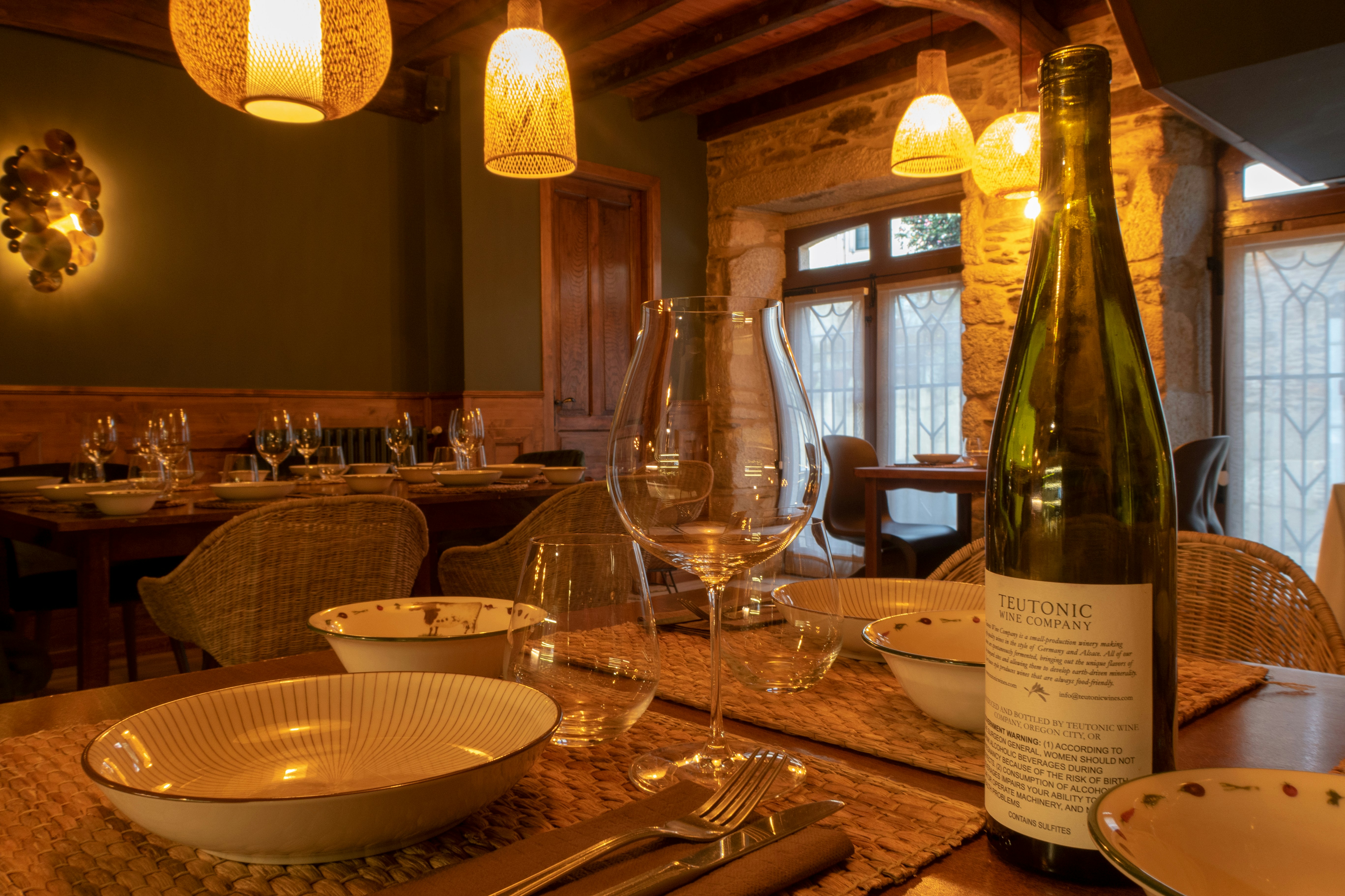 A table setting with wine bottle and glasses.
