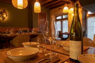 A table setting with wine bottle and glasses.