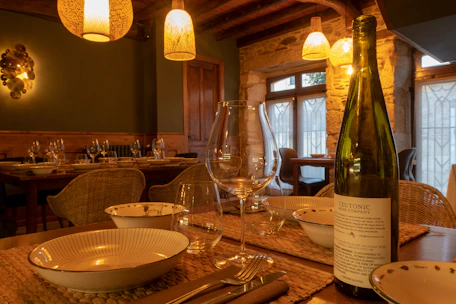 A table setting with wine bottle and glasses.