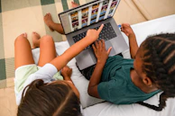 Two children looking at a laptop screen together