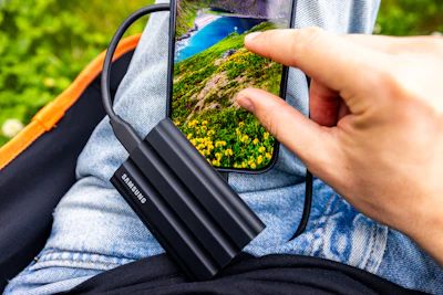 Person uses portable ssd with smartphone outdoors