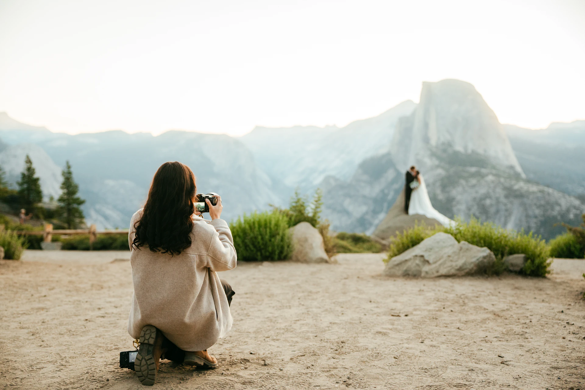 Couple posing for a photographer with a mountain backdrop