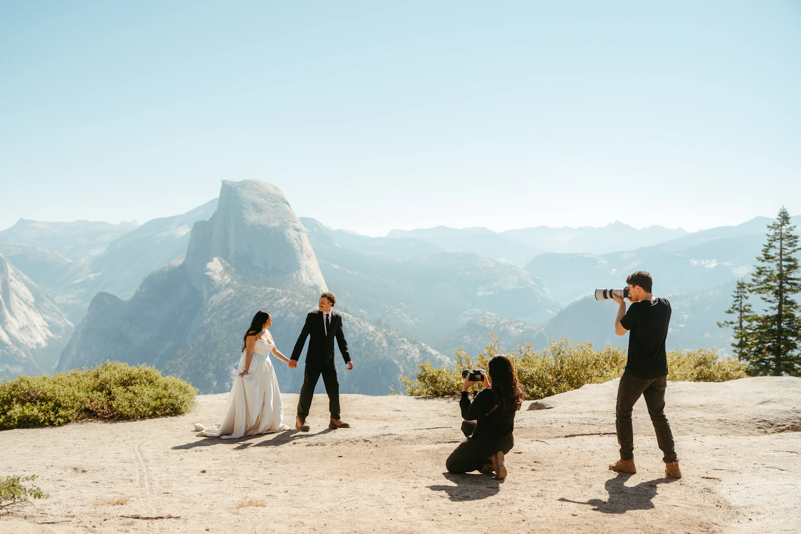 A photographer capturing a couple with a mountain backdrop, the kind of session that leads to a repeat booking