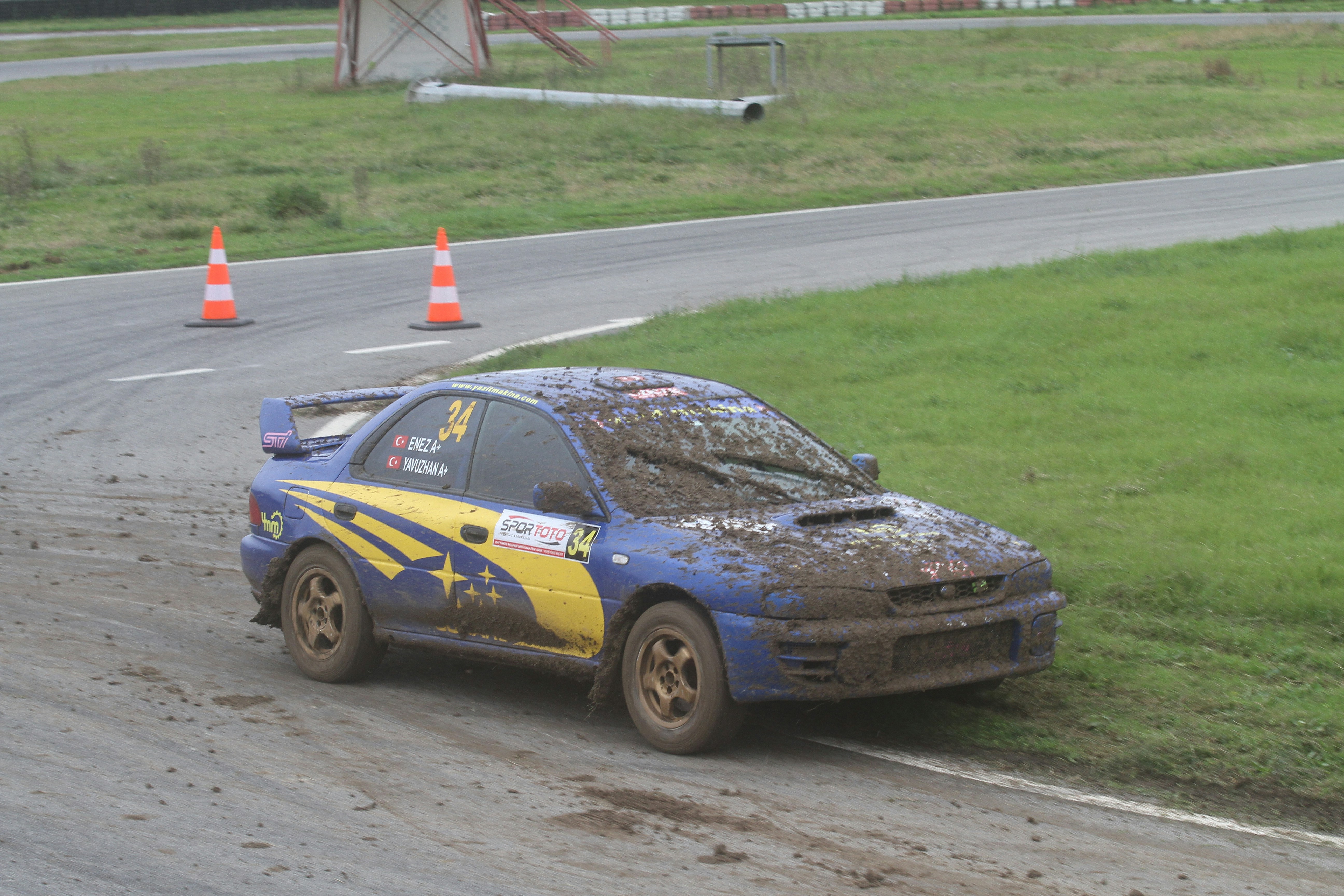 Mud-covered rally car on a dirt track