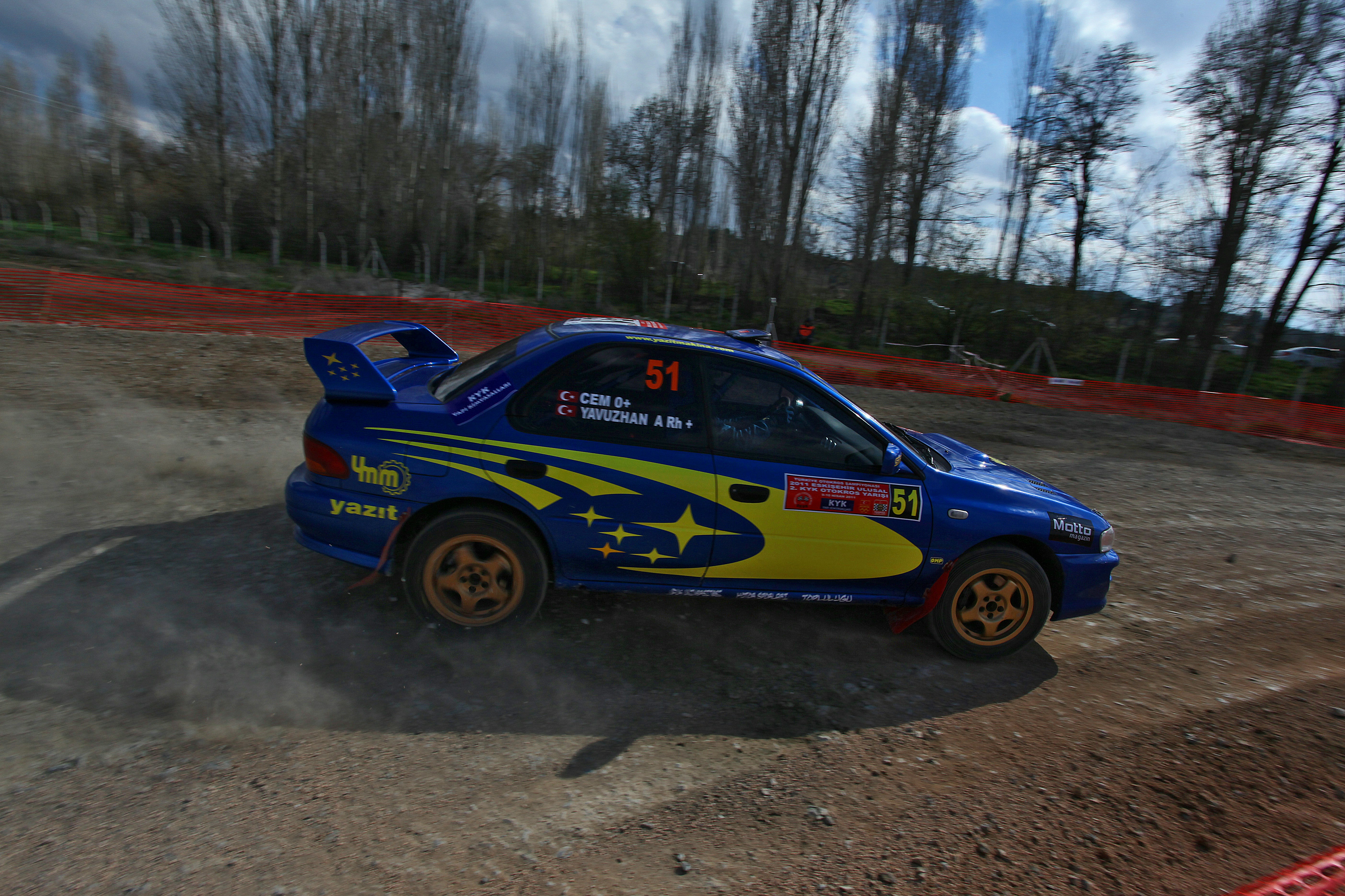 Blue rally car with yellow accents speeds on dirt track. photo – Free ...