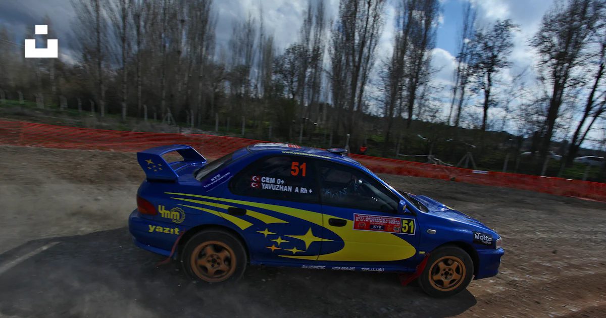 Blue rally car with yellow accents speeds on dirt track. photo – Free ...