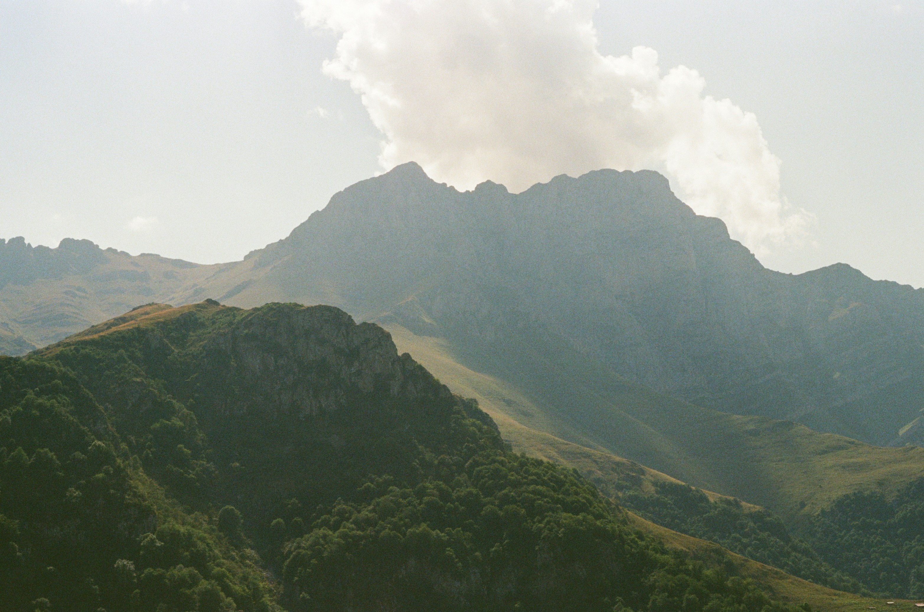 Misty mountains with green slopes under a cloudy sky