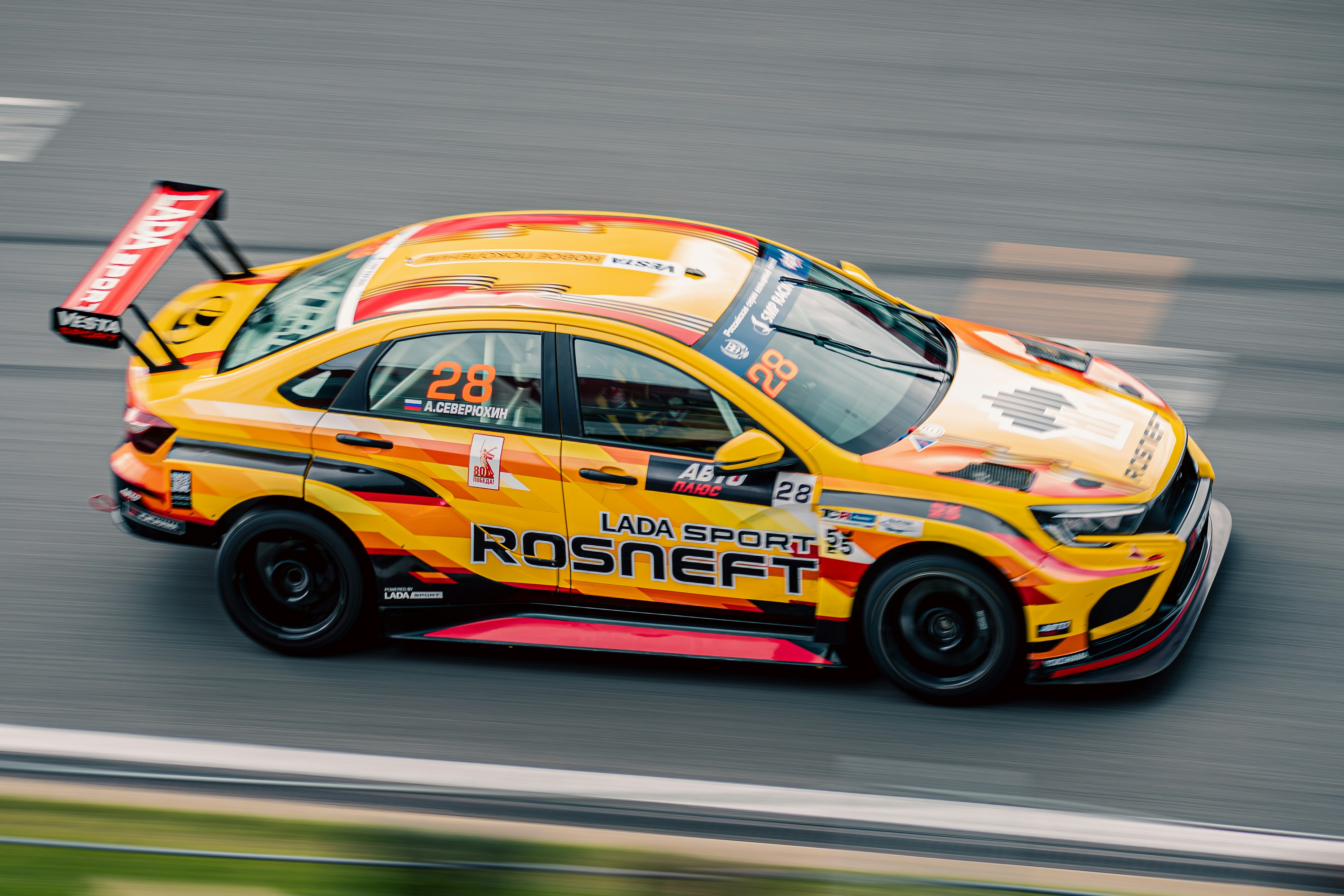 Race car with sponsor logos speeds around track. photo – Free Laptop ...