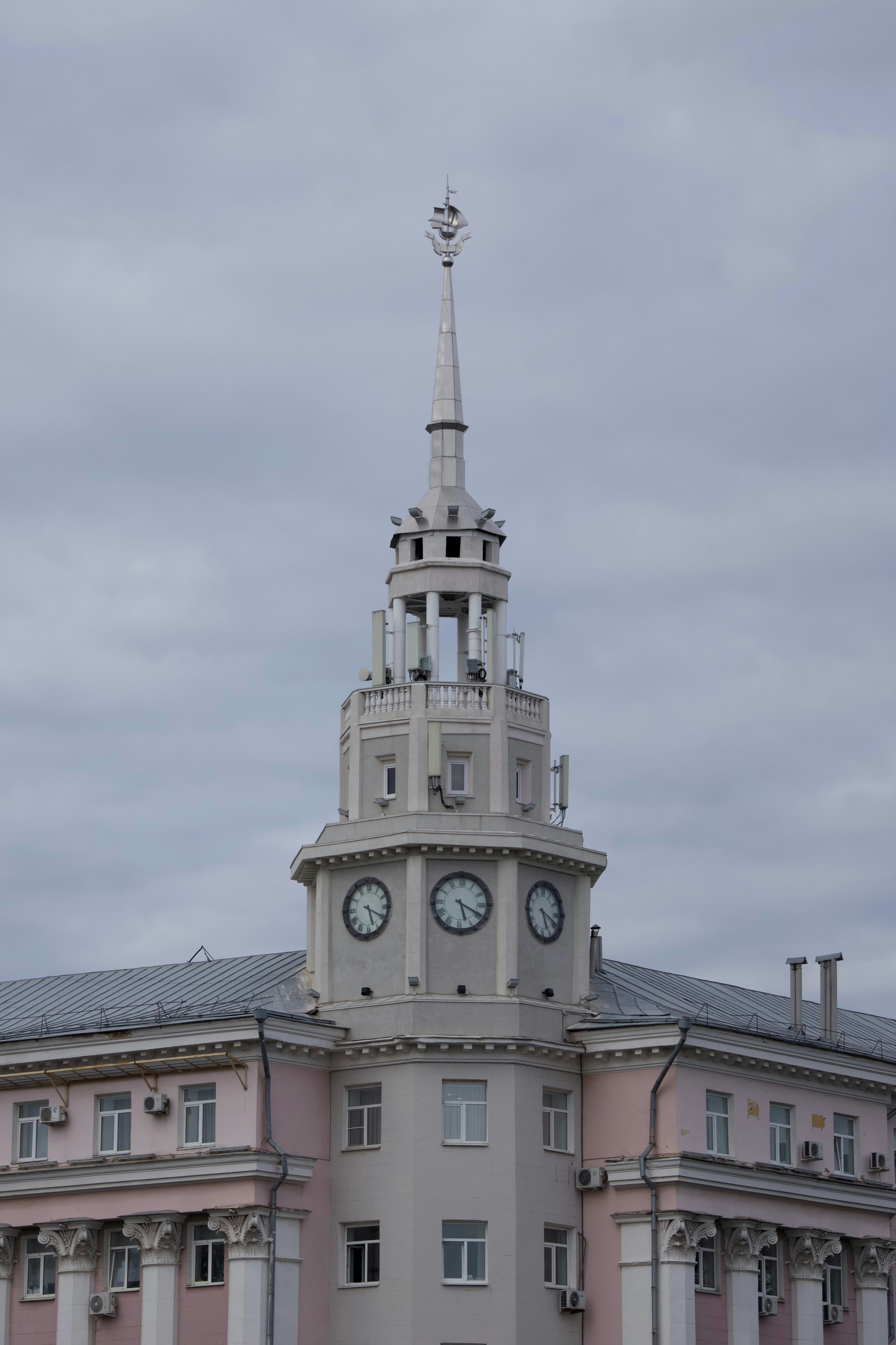 Tall building with a clock tower and spire.