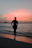 Silhouette of a woman on a beach at sunset.