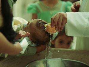 Baby being baptized with water poured on head