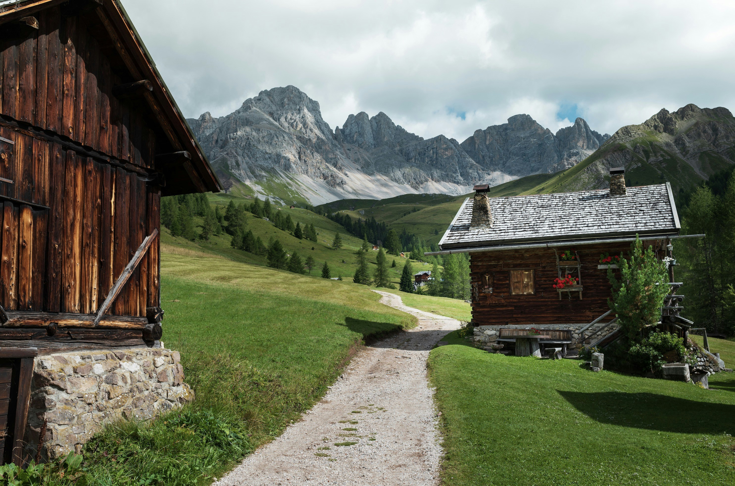 Wooden cabins on a grassy mountain path