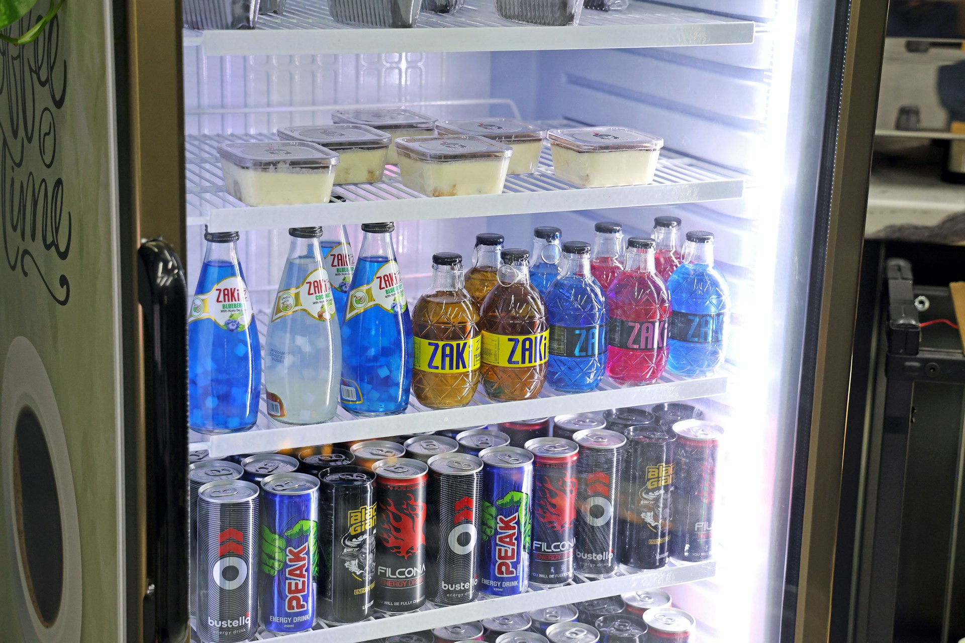 Refrigerated display case filled with drinks and desserts.