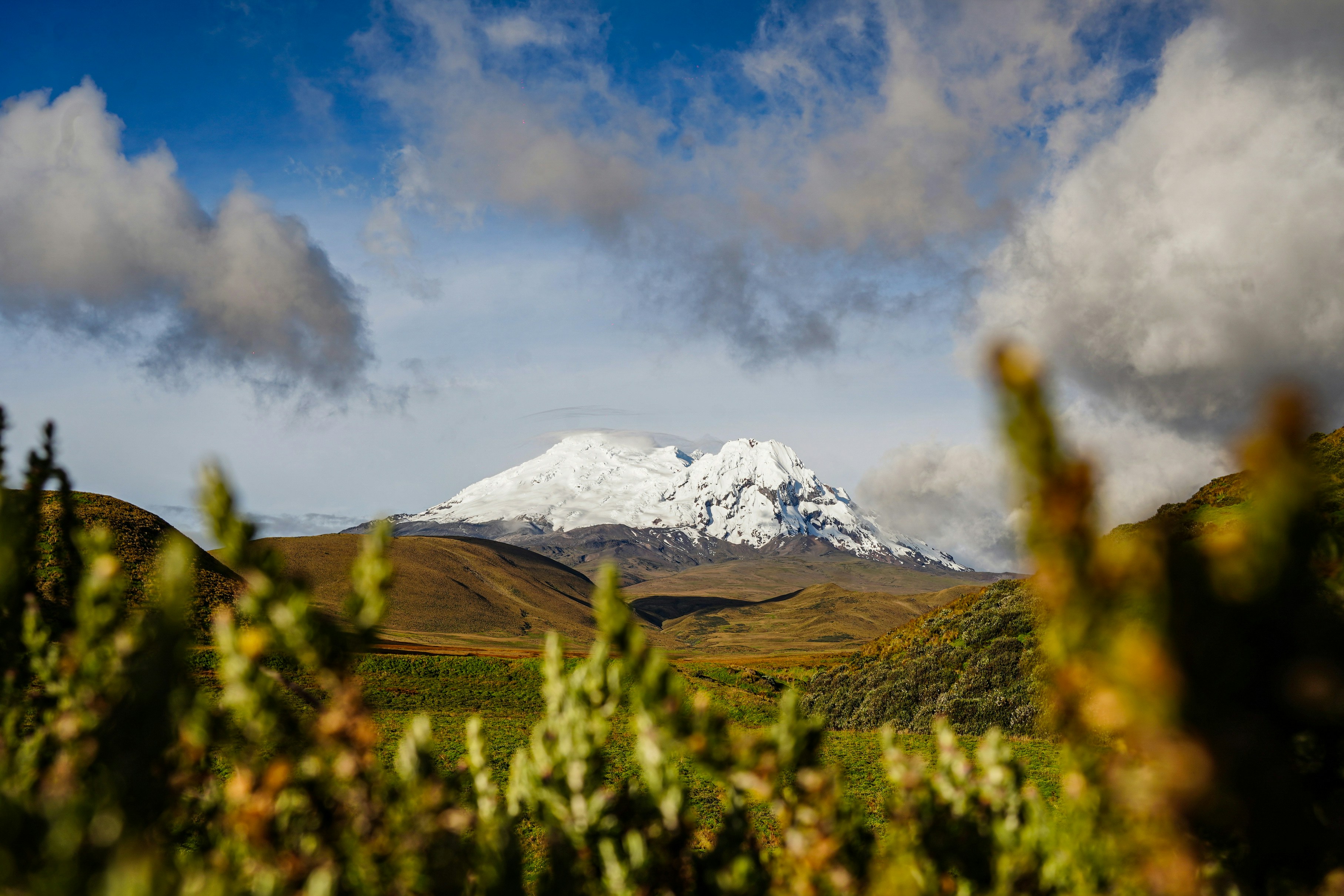 Snow-capped mountain peak under cloudy blue sky