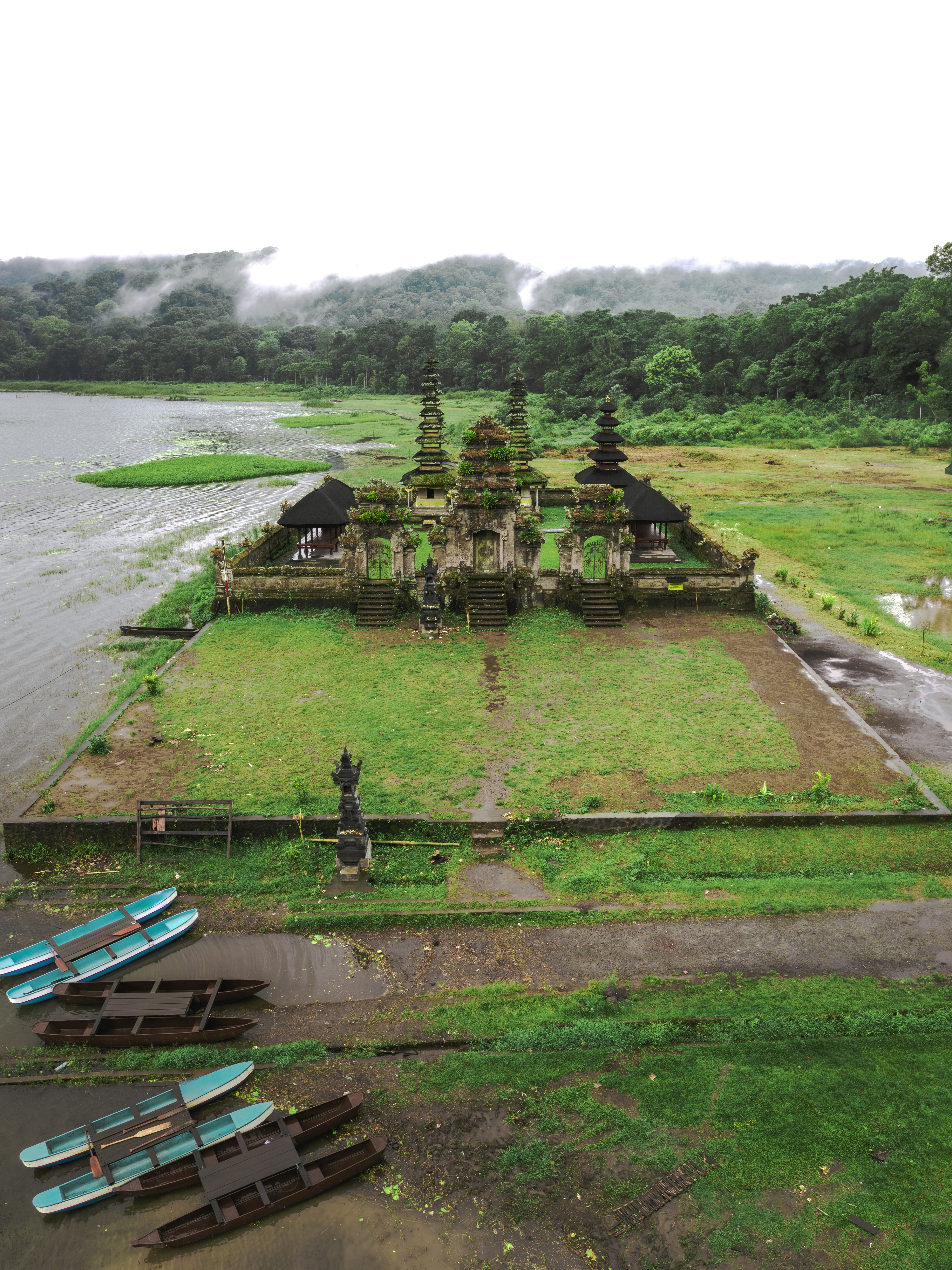 Ancient temple complex on a grassy field near lake