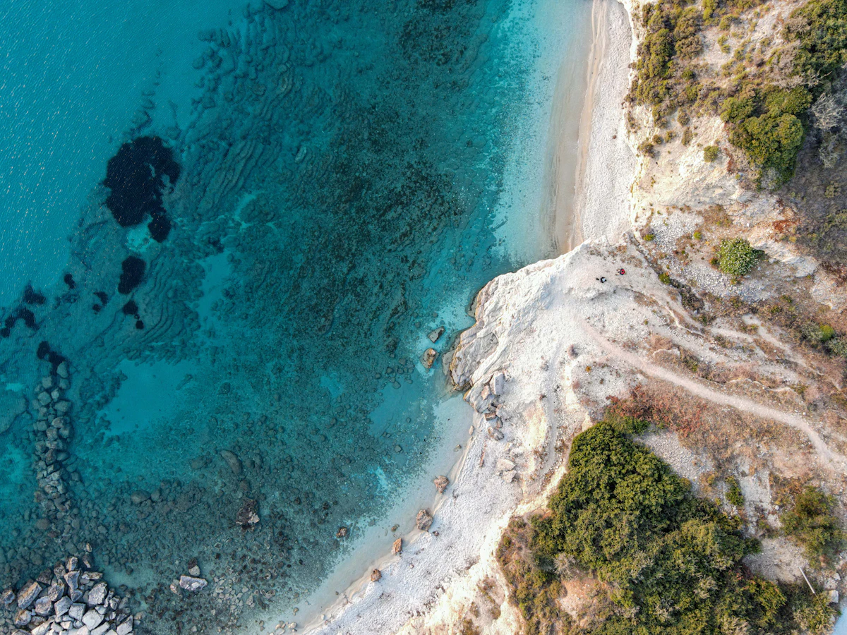 Aerial view of a white sandy beach meeting turquoise water