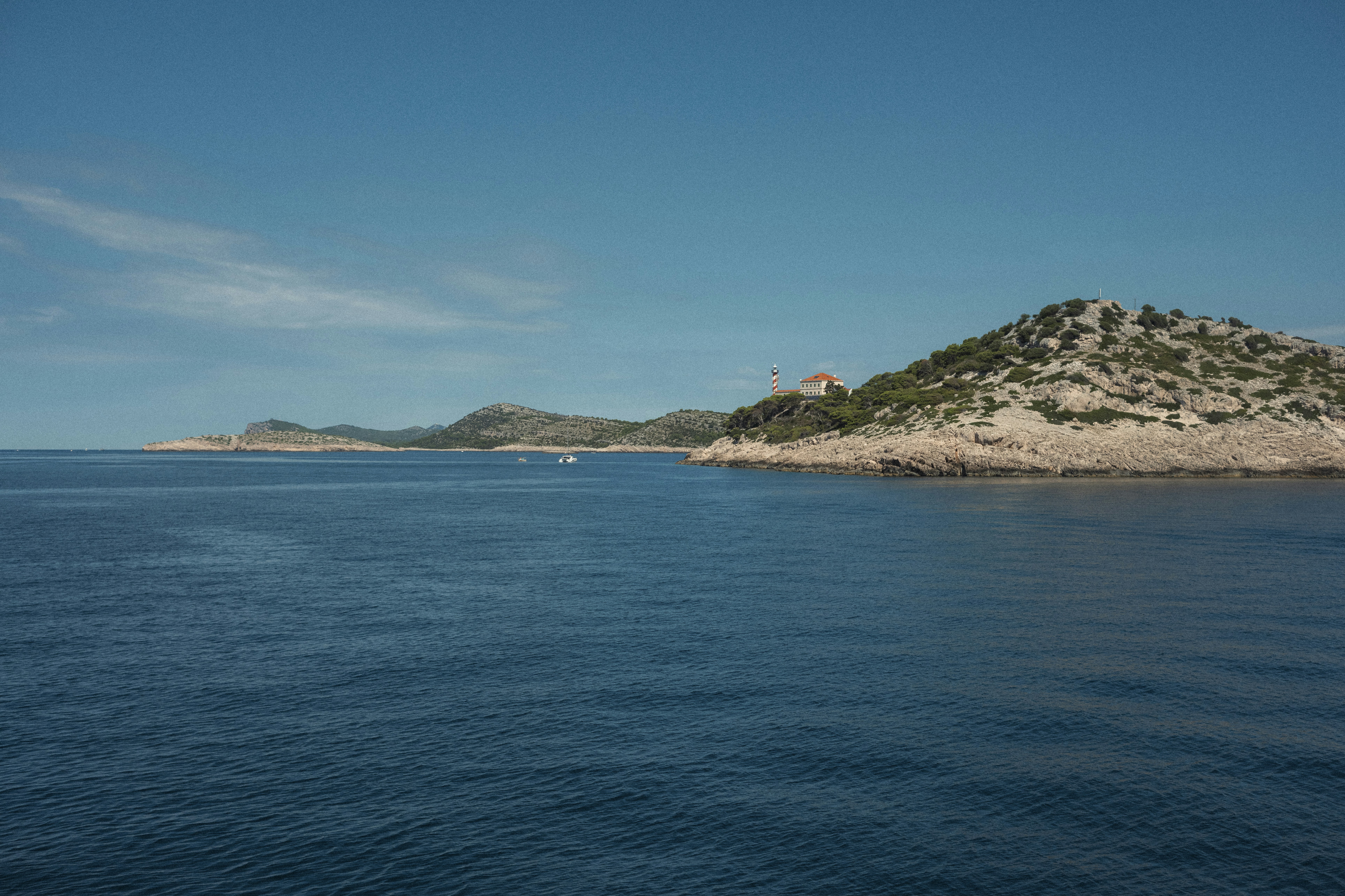 Calm blue ocean waters with a rocky island shore.