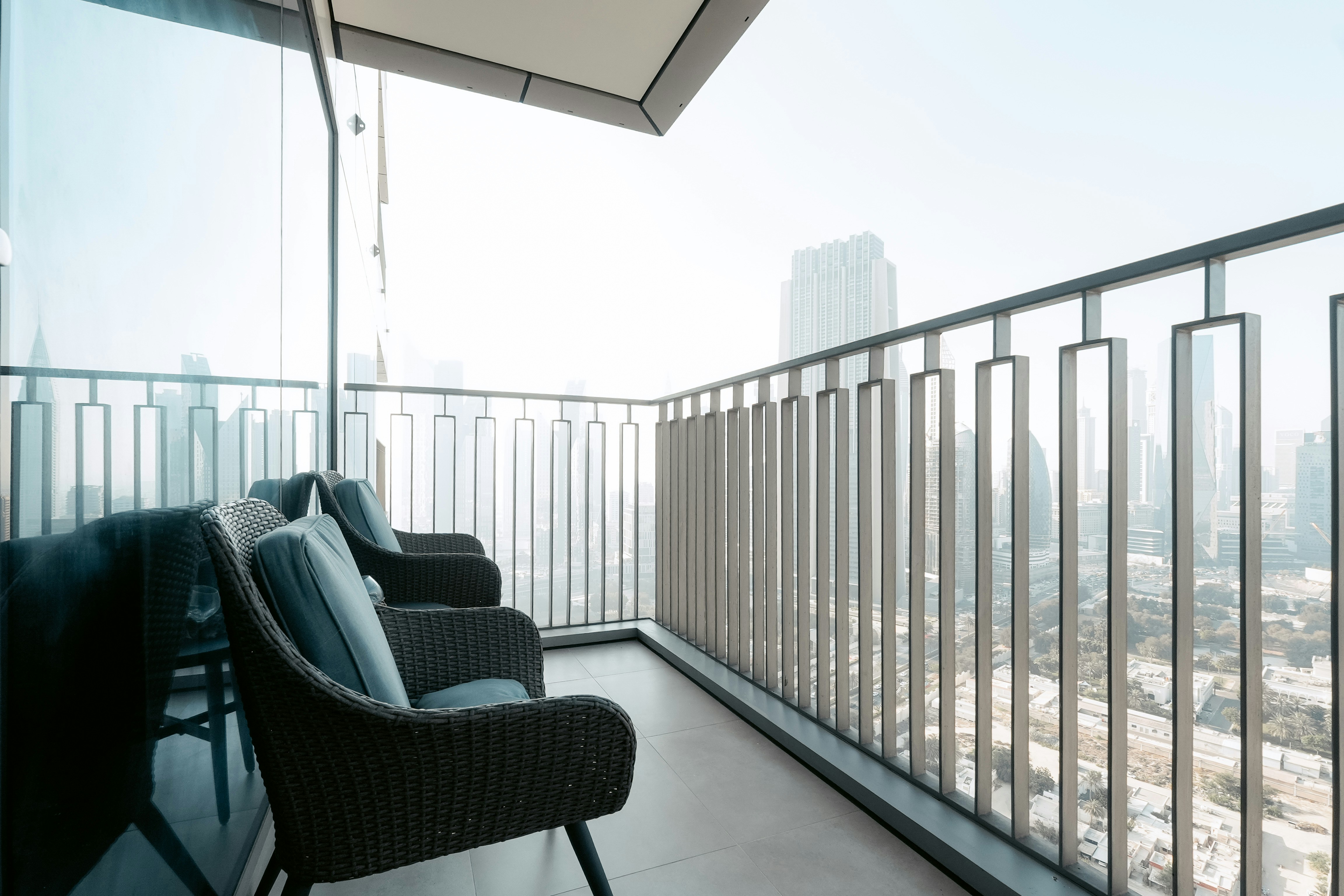 Two chairs on a balcony overlooking a cityscape