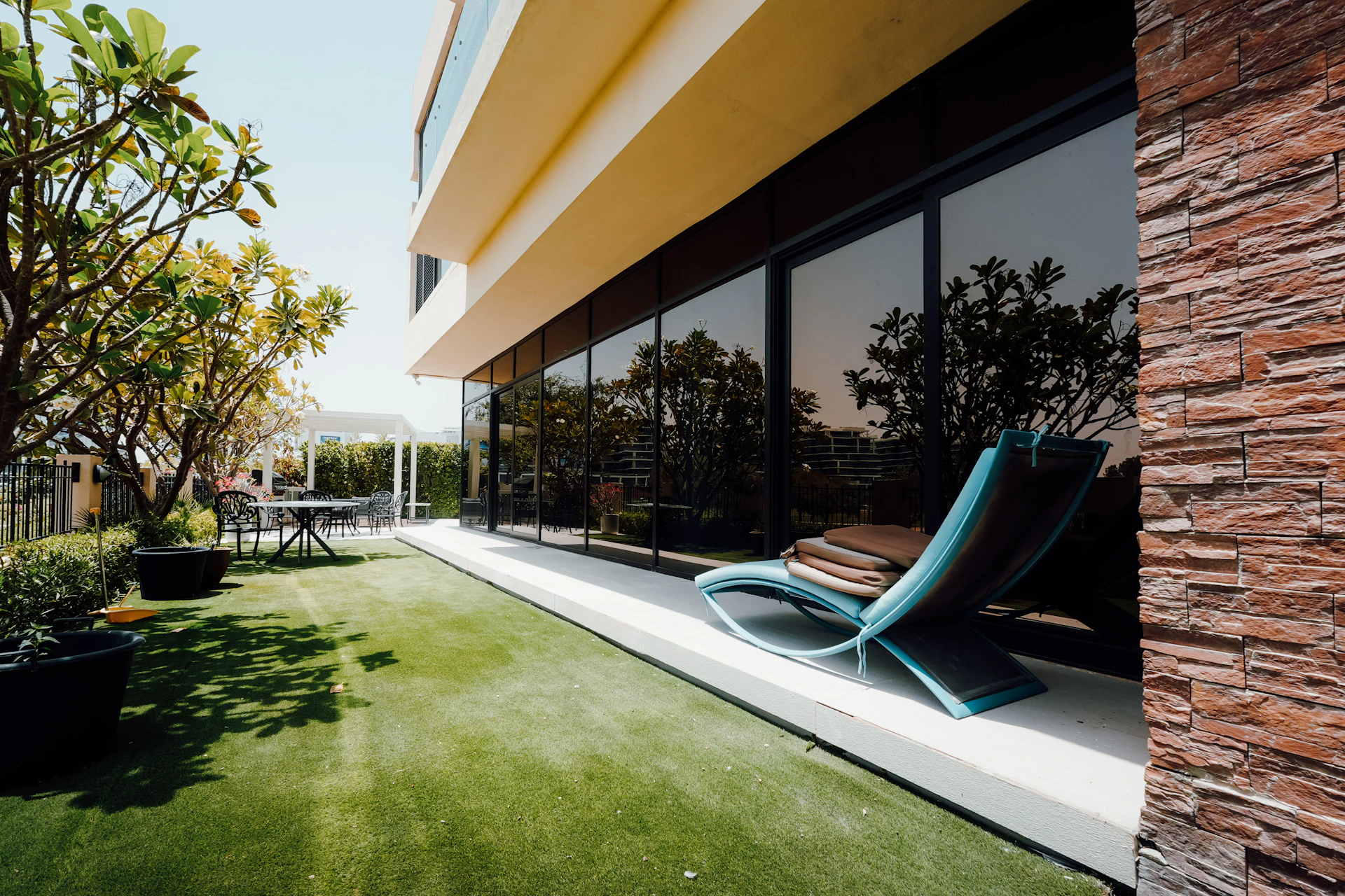 Modern balcony with lounge chair and artificial grass.