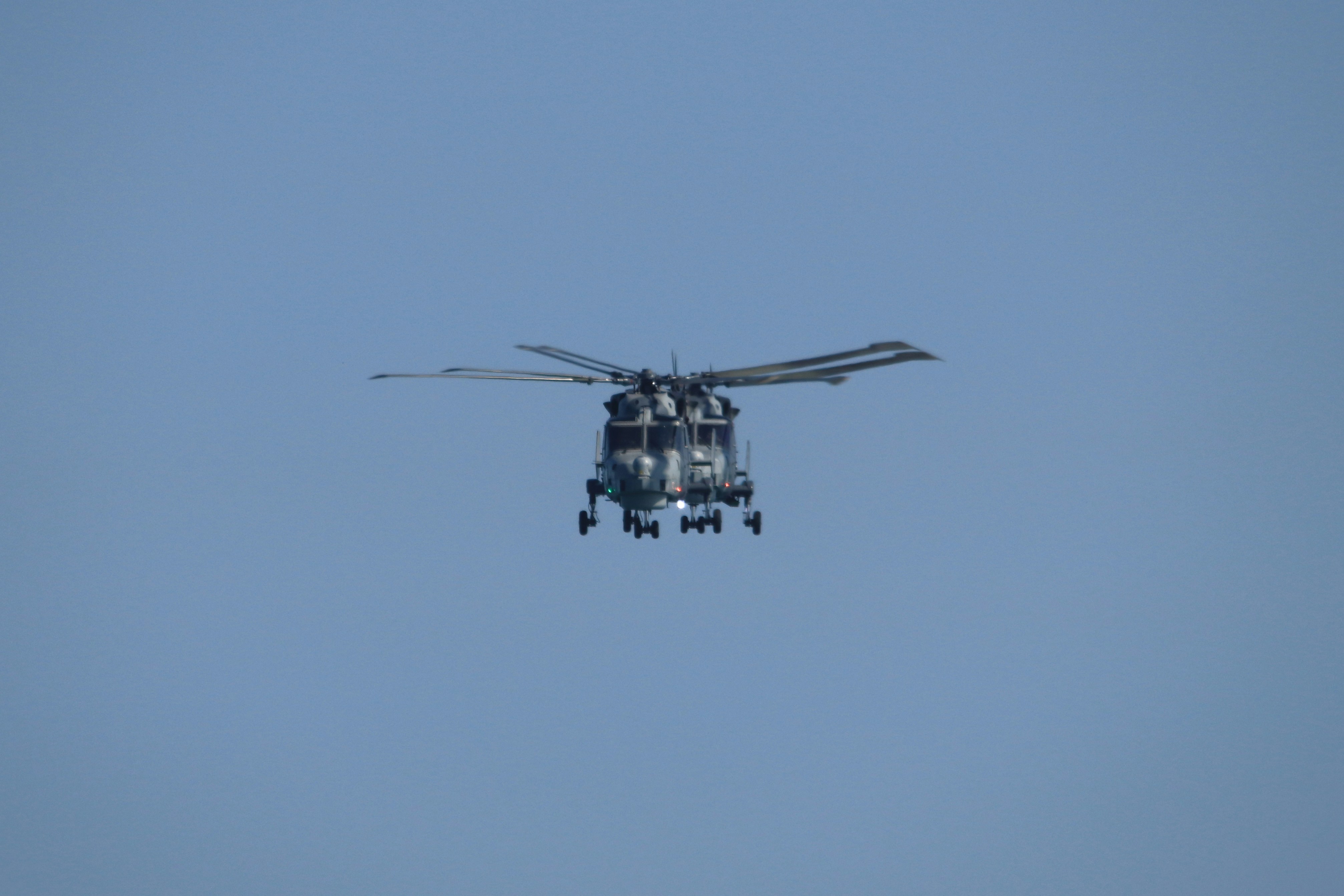 Military helicopter flying in clear blue sky