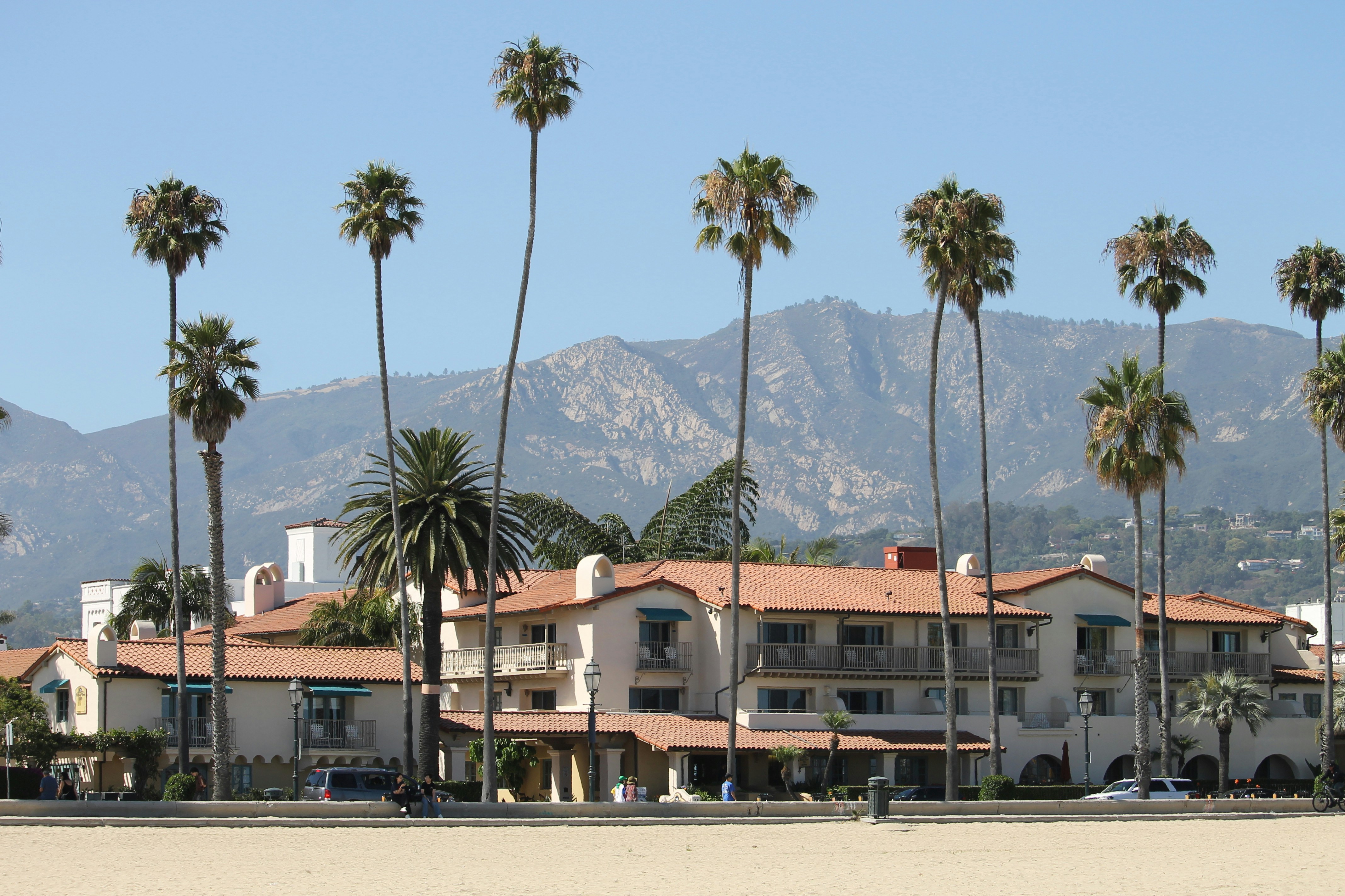 Building with palm trees and mountains in background