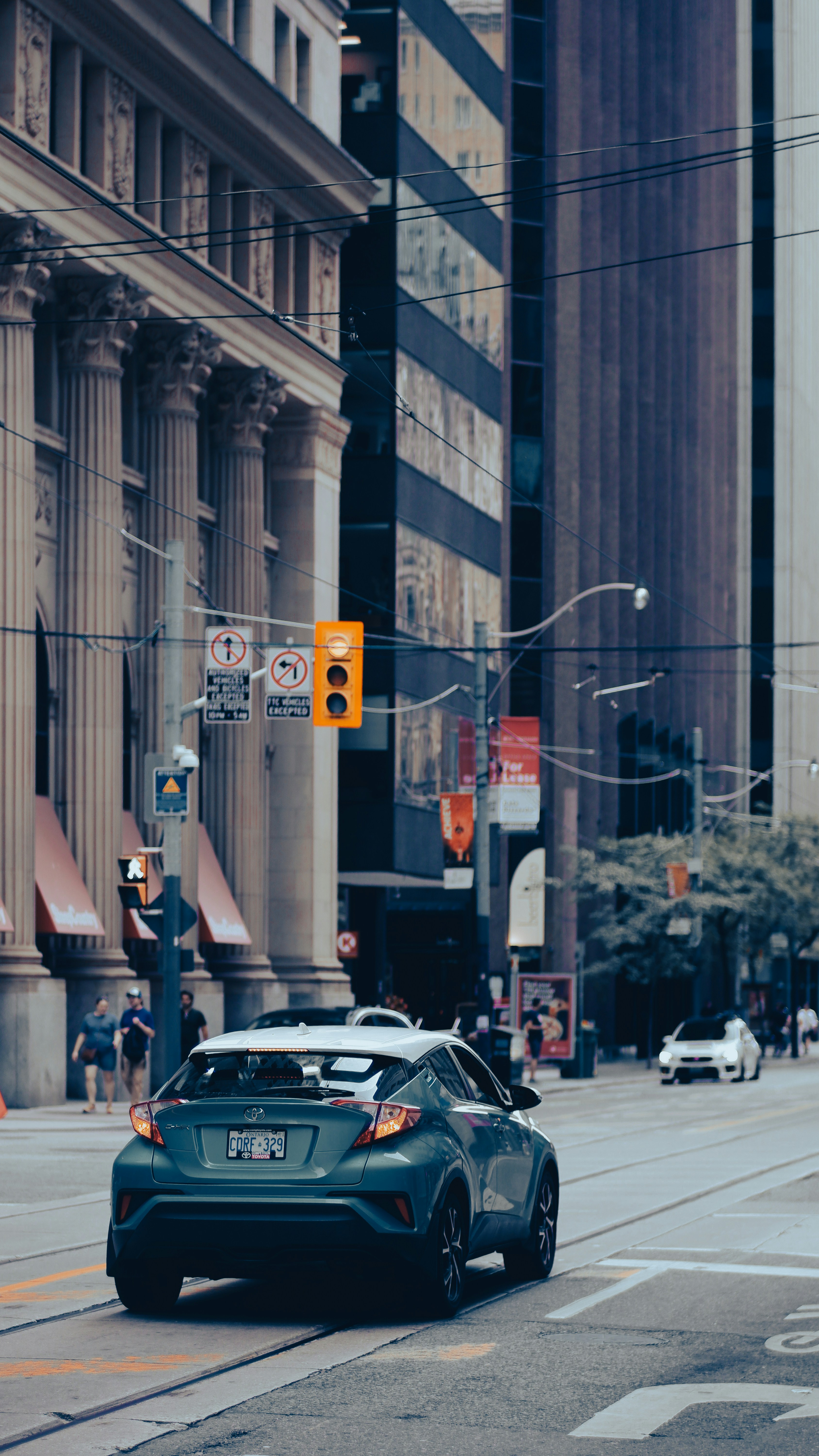 Car driving on a city street with buildings and buildings photo – Free ...