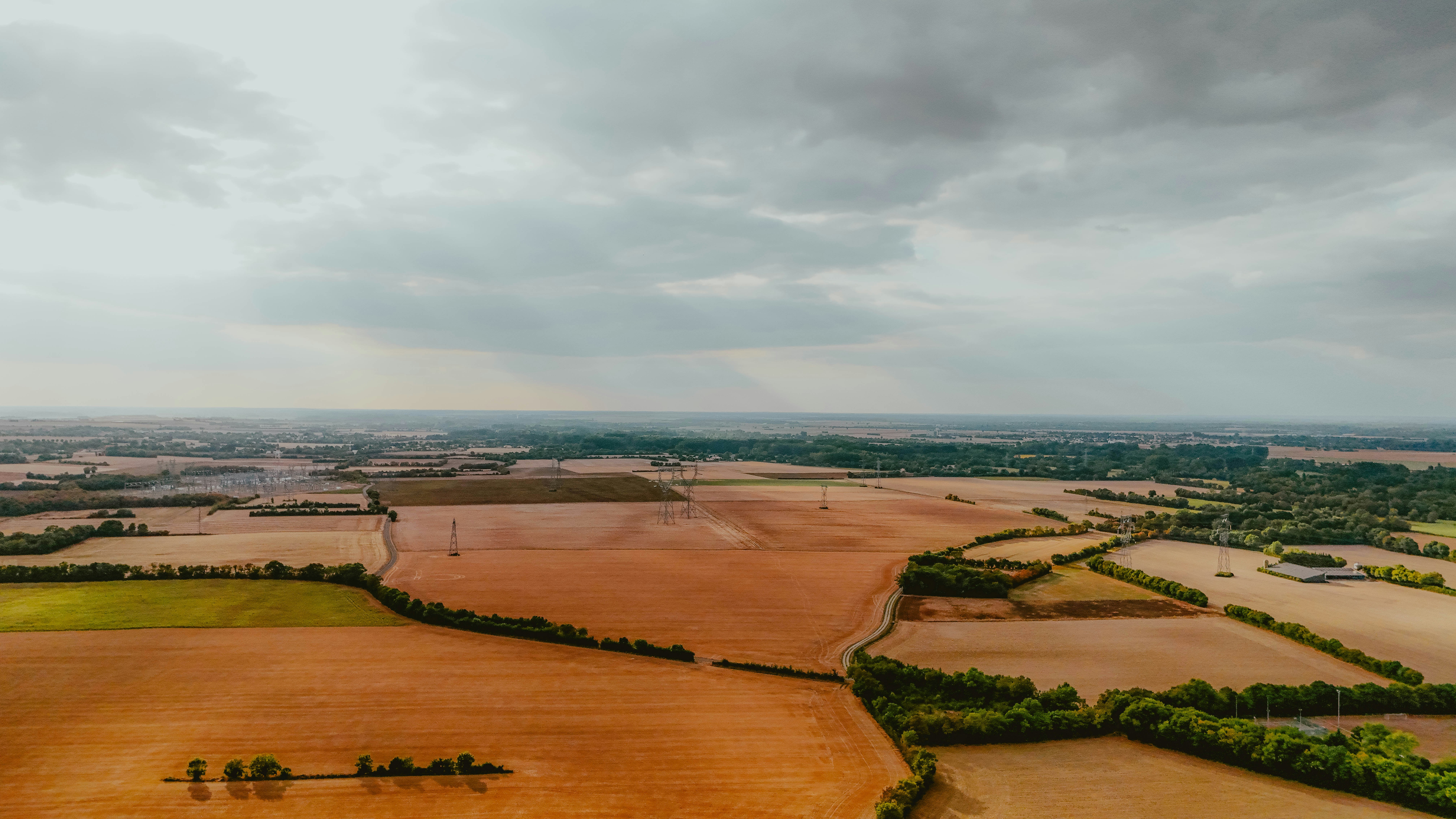 Aerial view of agricultural fields under a cloudy sky.