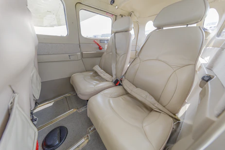 Interior of a small airplane with beige leather seats.