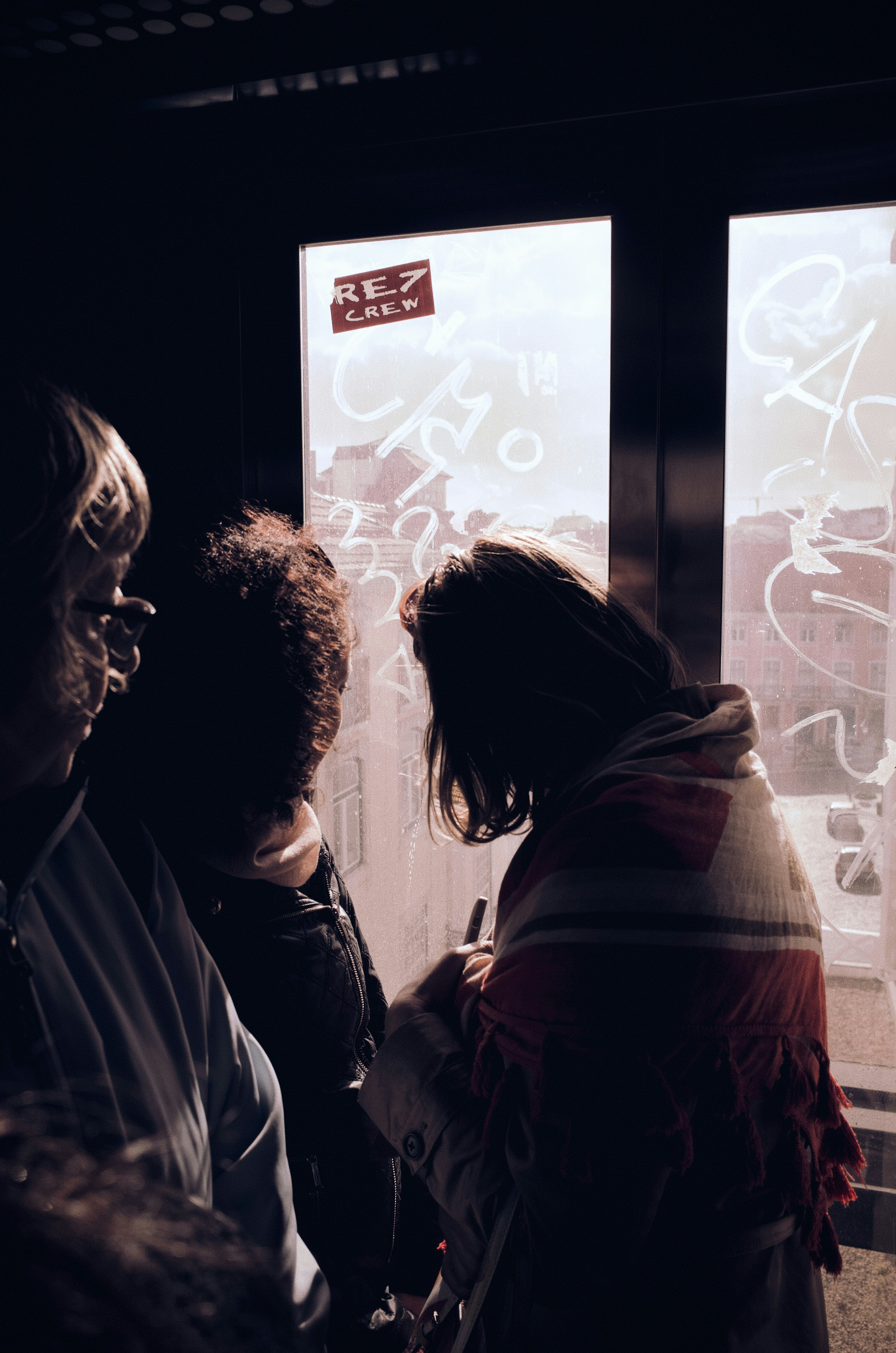 Des gens se sont rassemblés près d’une fenêtre avec des graffitis.