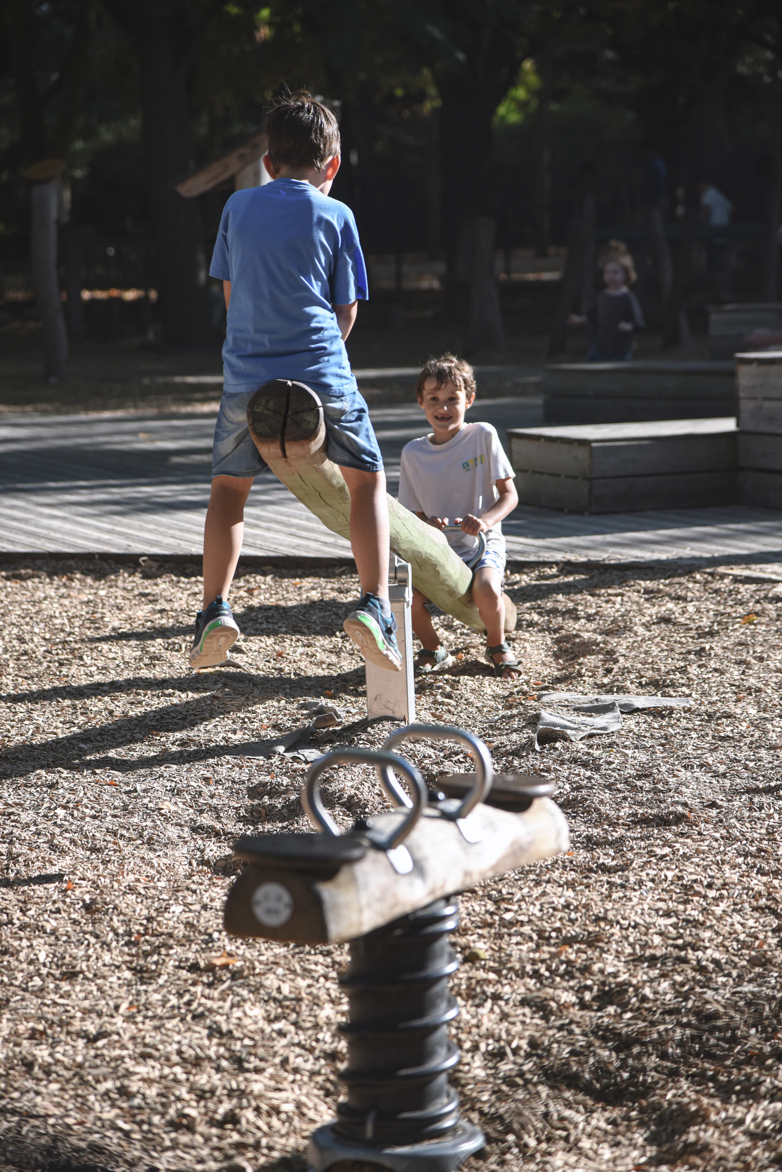 Two children balancing on a seesaw at a playground