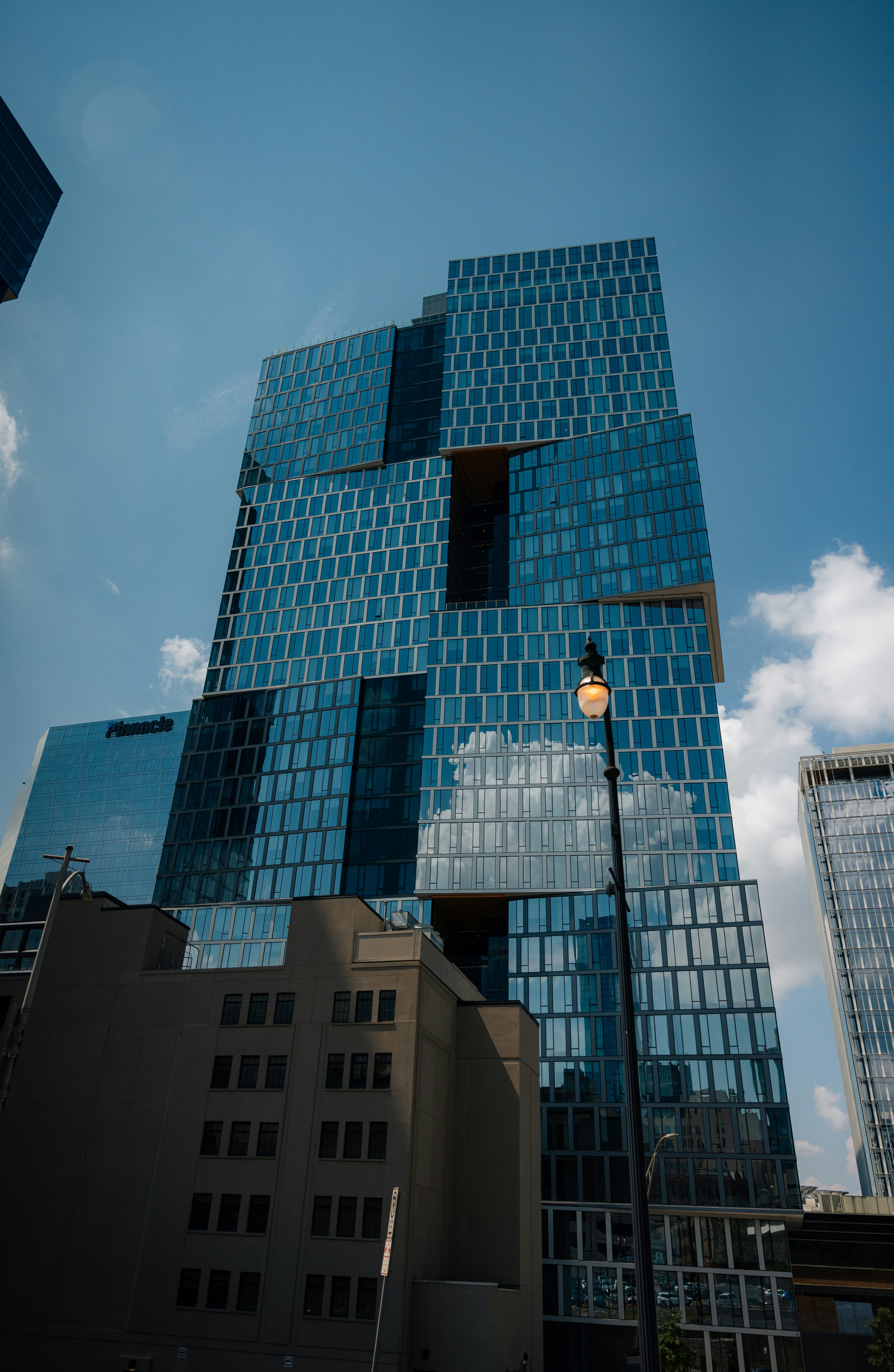 Modern glass skyscraper against a blue sky.