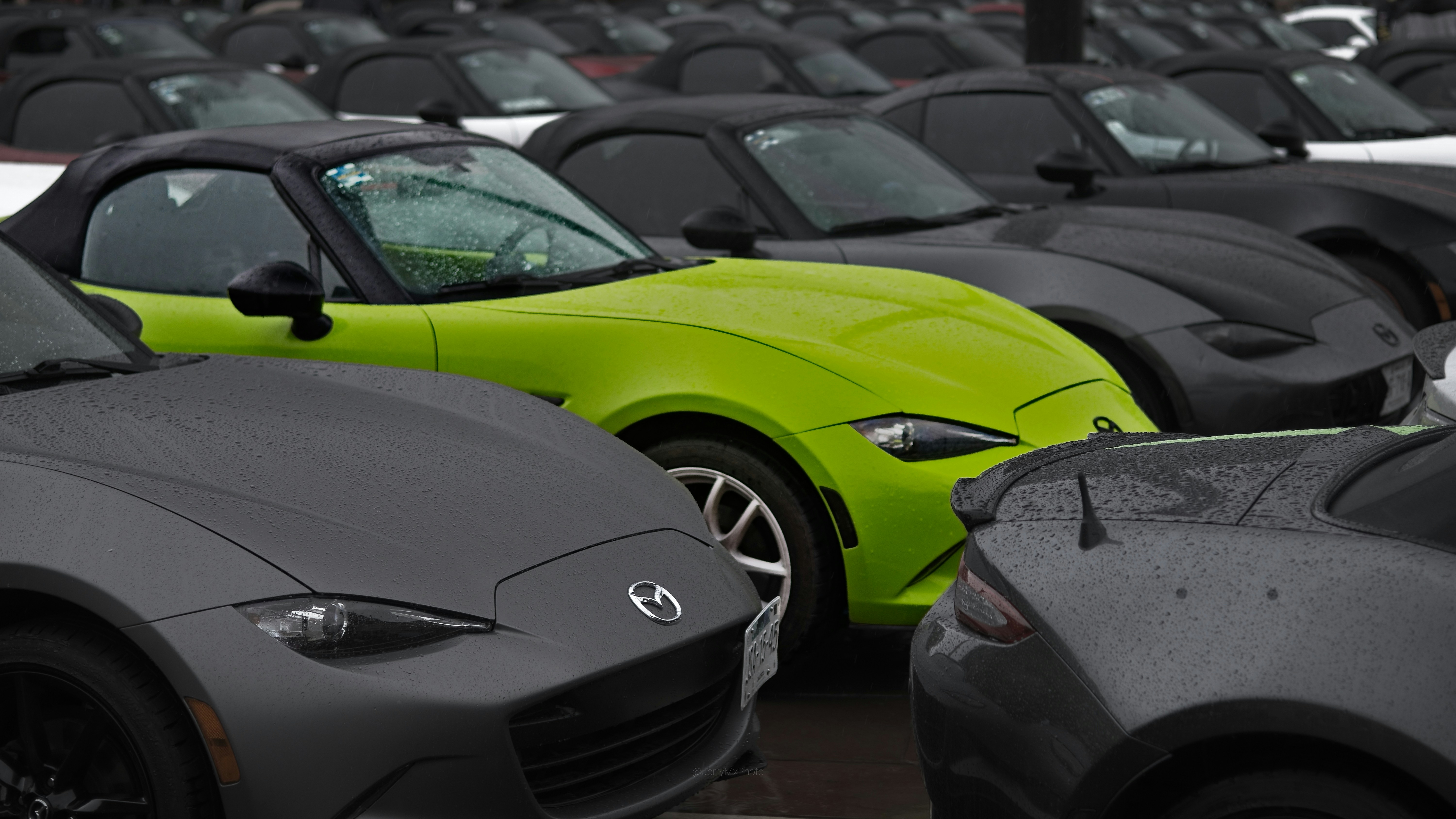 Row of used electric cars lined up for sale at a dealership lot