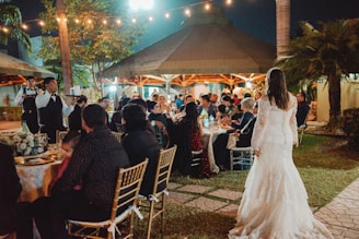 Wedding reception with guests seated outdoors at night.