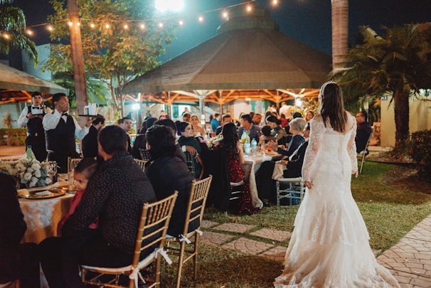 Wedding reception with guests seated outdoors at night.
