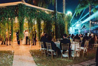 Wedding reception with guests seated at tables outdoors.