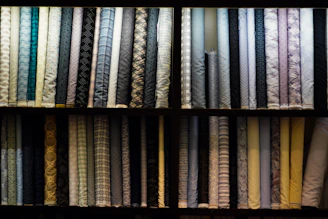 Shelves of rolled fabric with various patterns.
