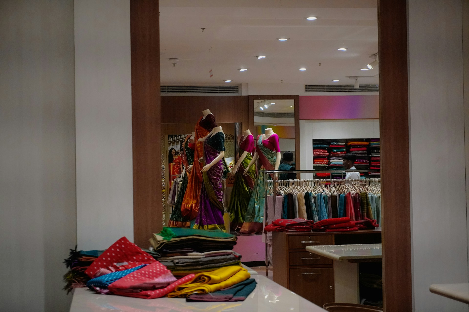 Mannequins display colorful saris in a retail store.