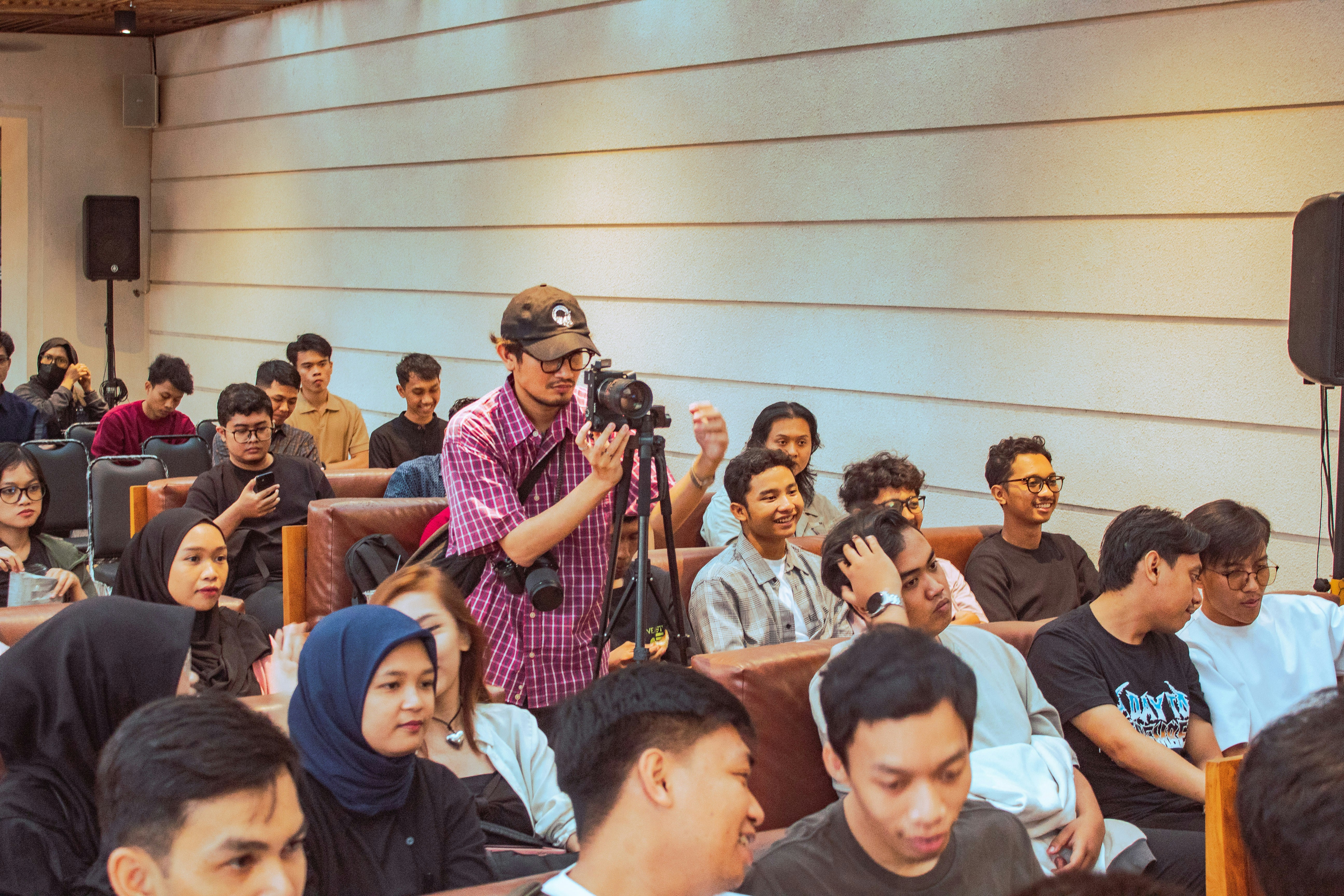 A person films an audience with a video camera.