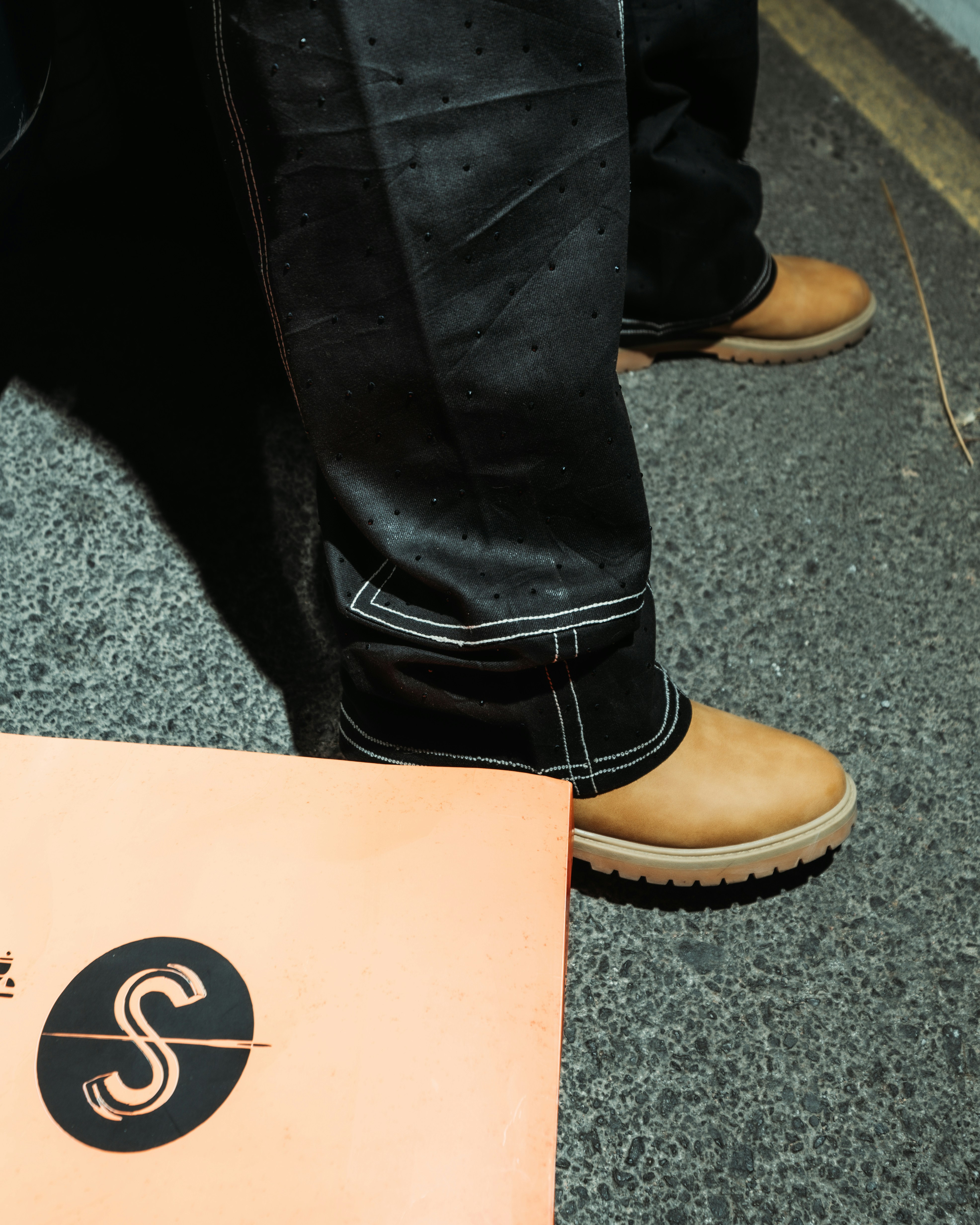 Person wearing black pants and tan boots