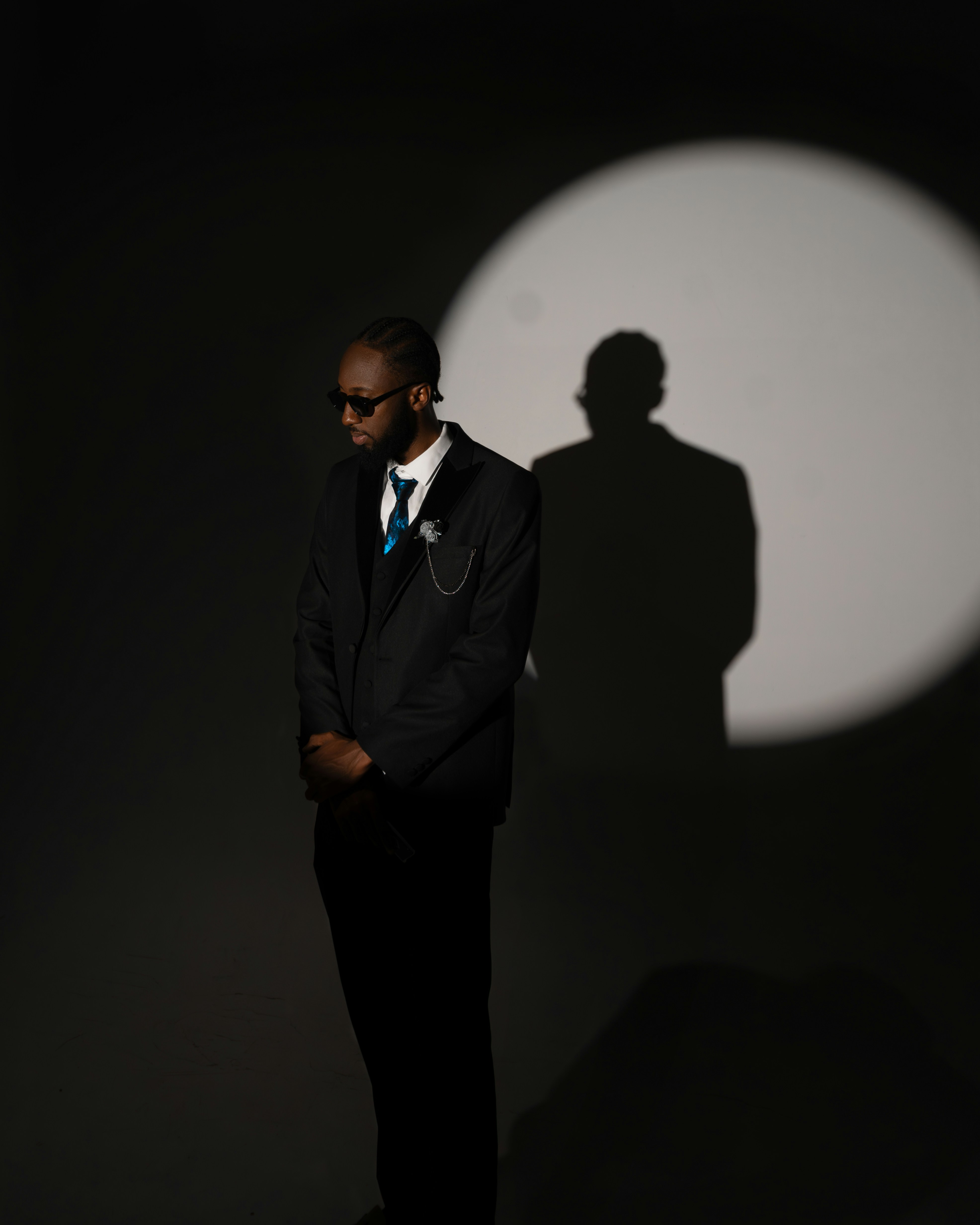 Man in a suit stands in a spotlight