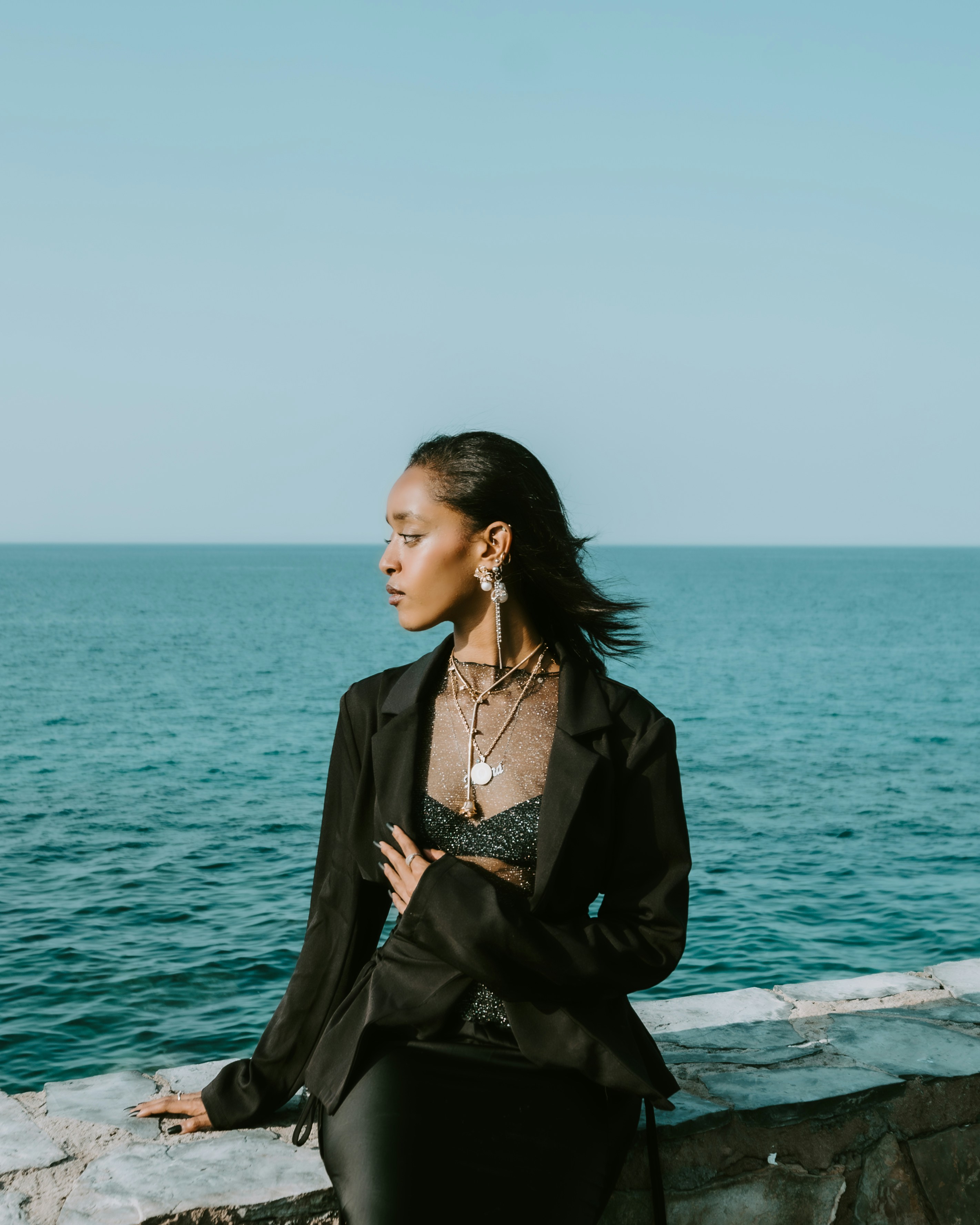 Mujer con blazer negro junto al océano