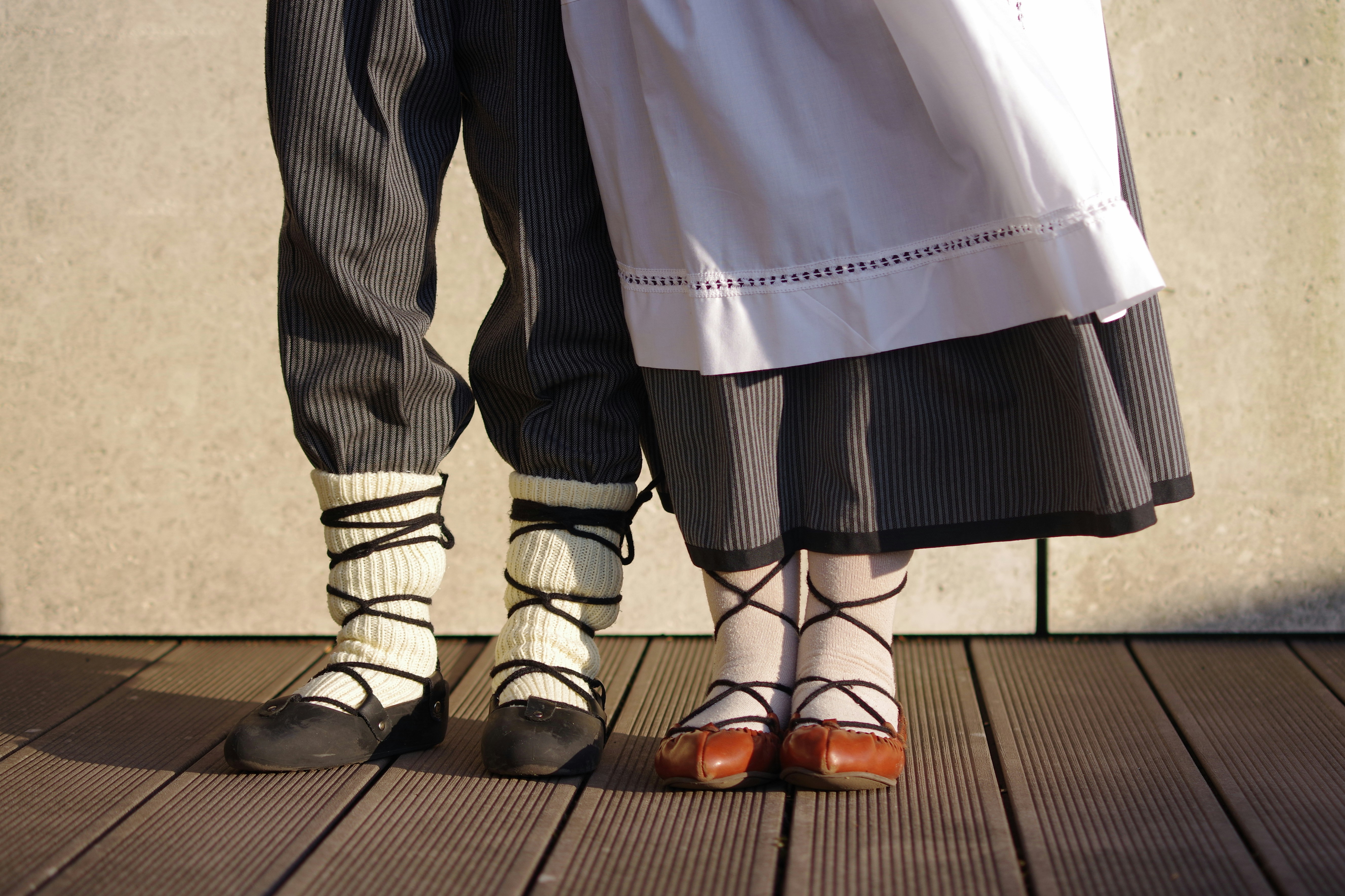 Two people wearing traditional folk costumes and shoes.