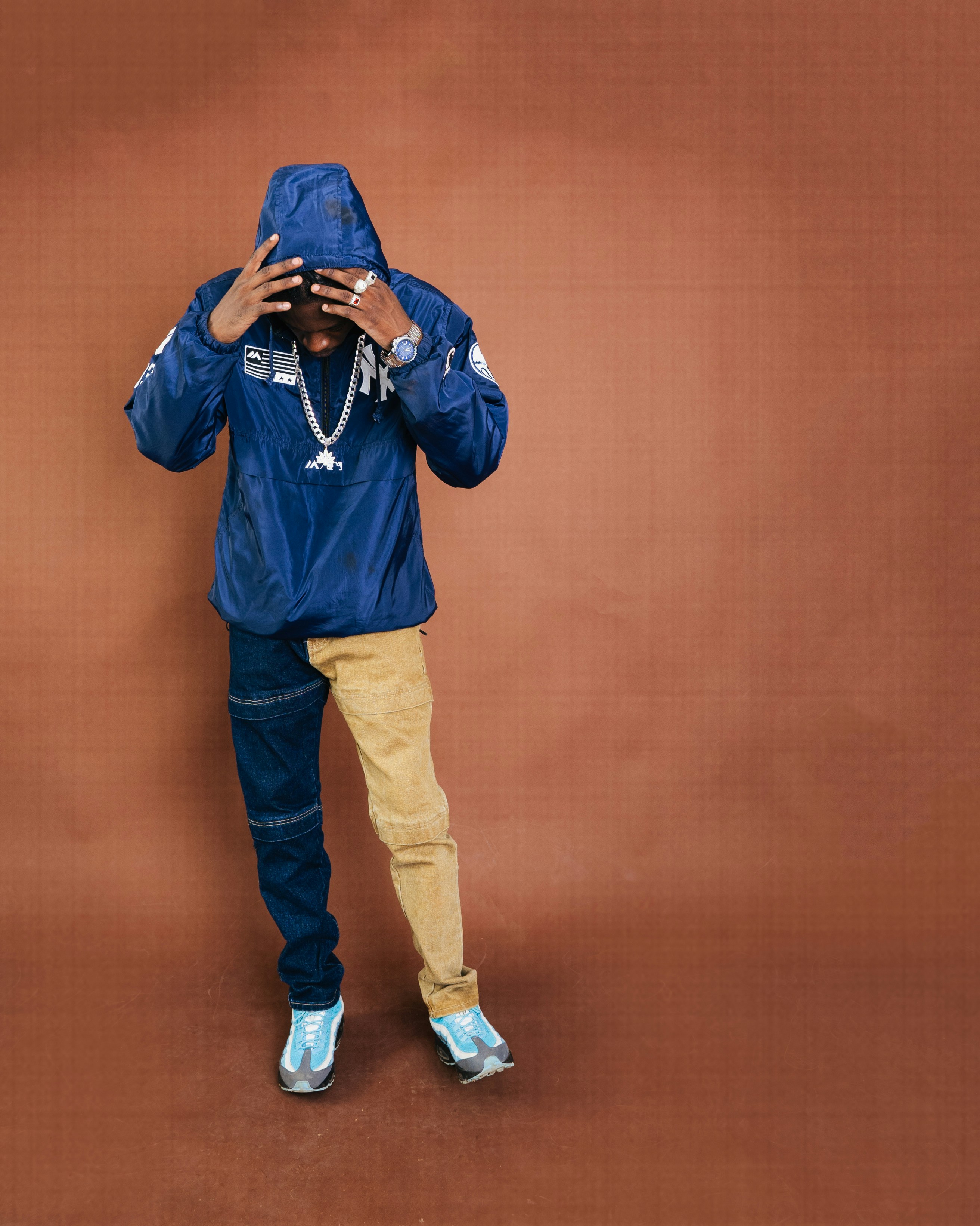 Pria berjaket biru dan celana dua warna menutupi mata.