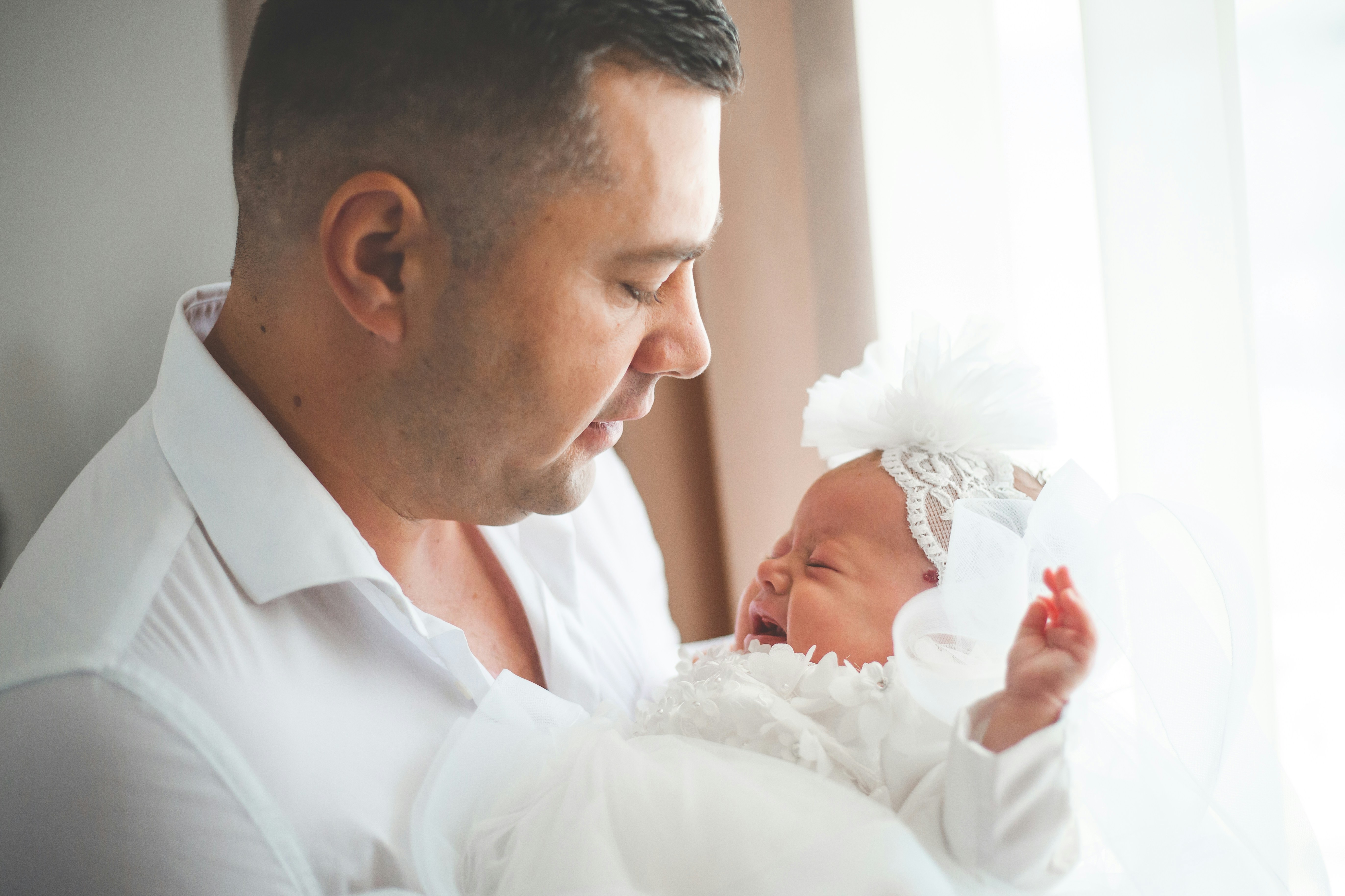 Père tenant sa petite fille nouveau-née en pleurs