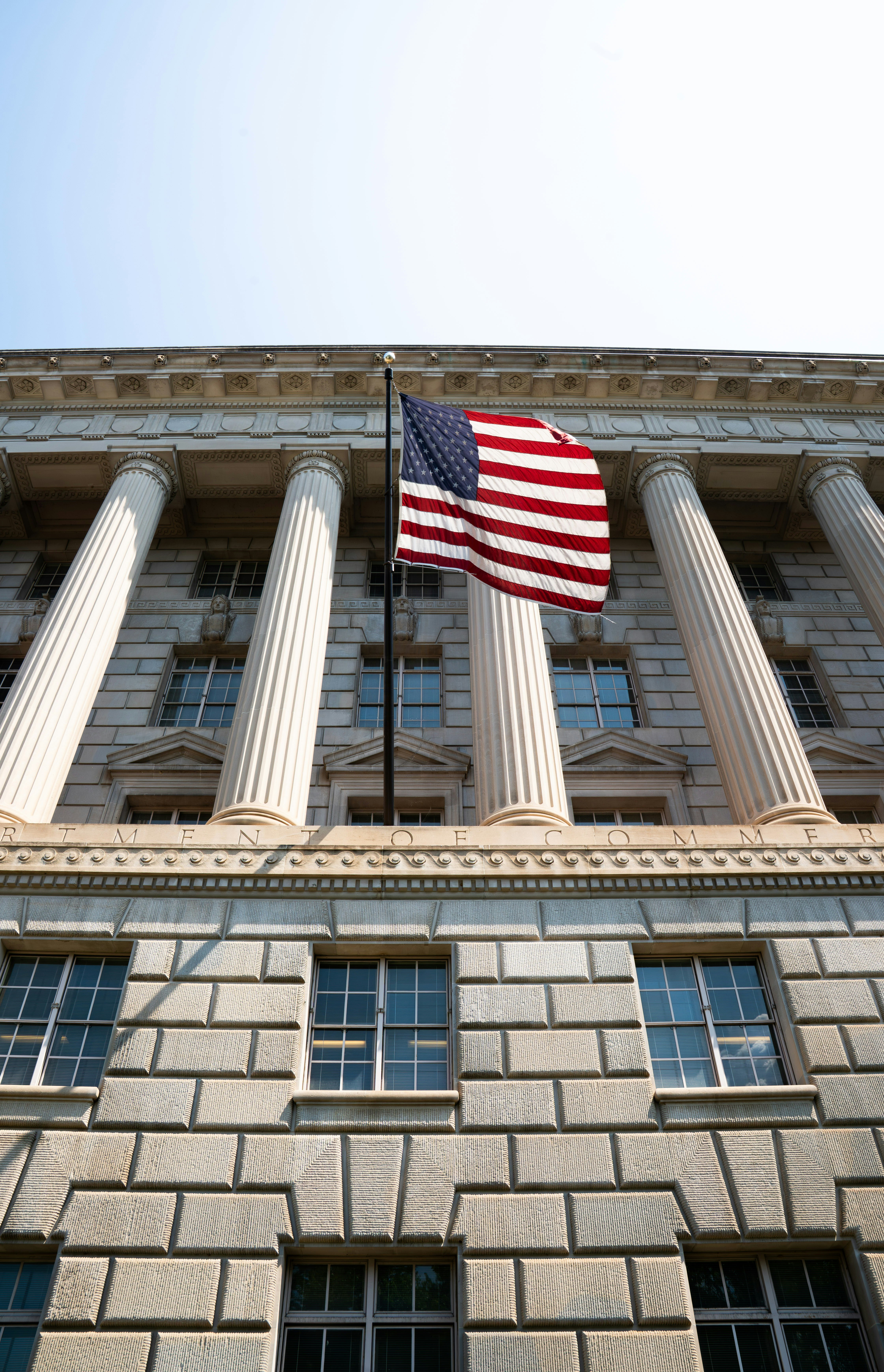 American flag flies in front of neoclassical building